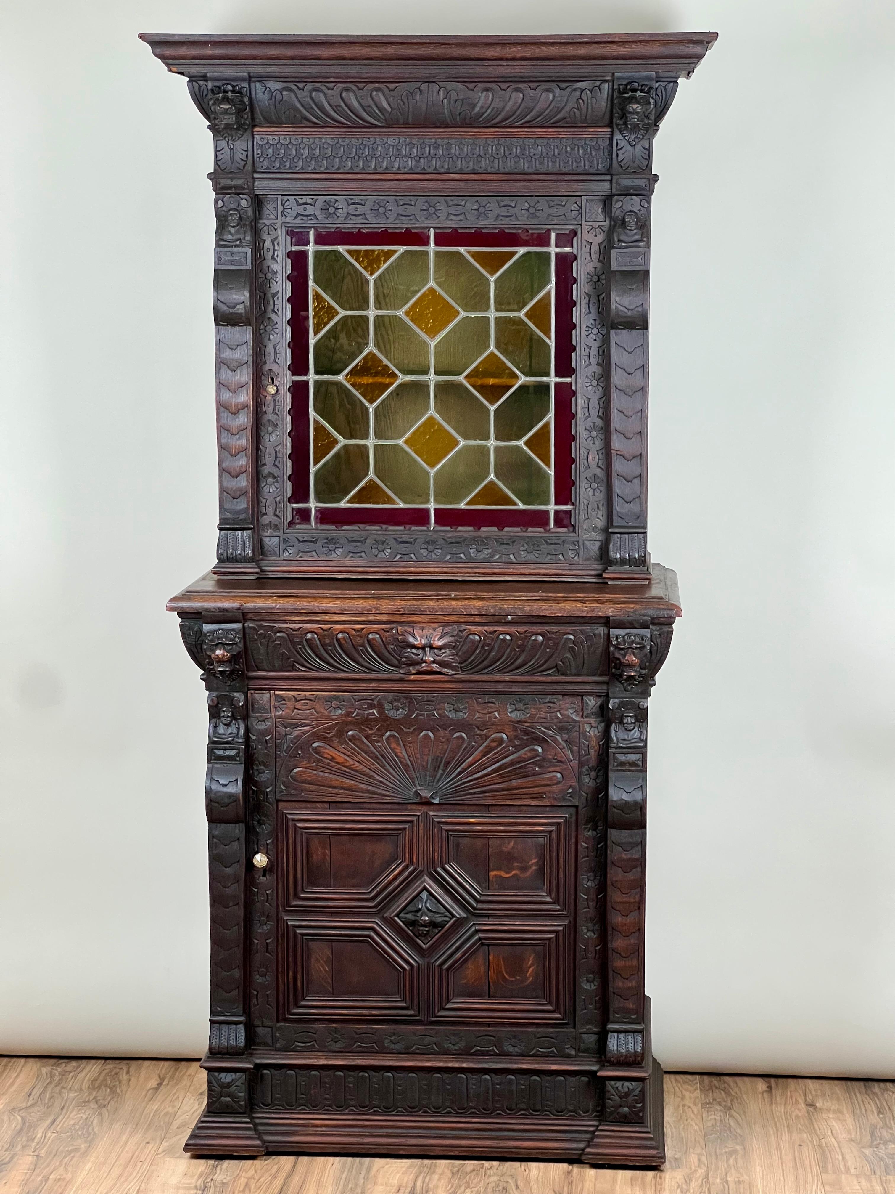 Dieser antike Schrank aus geschnitzter Eiche im Stil der Gotik-Revival-Kunst ist reich an Details und zeugt von der Faszination der Epoche für Handwerkskunst, Symbolik und Dramatik. Der Schrank ist aus massiver Eiche geschnitzt und zeigt durchgehend