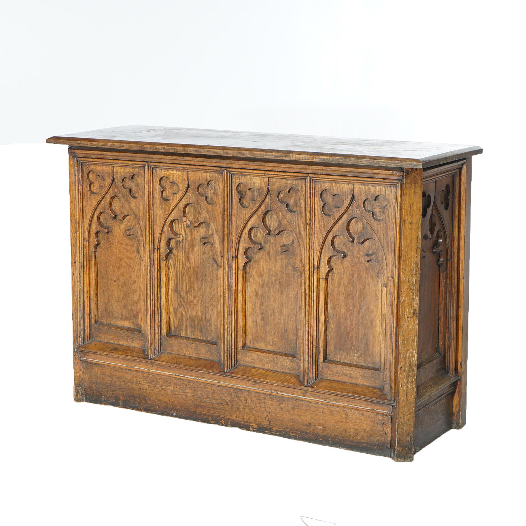 An antique Gothic Revival console table offers quarter sawn oak paneled construction with carved stylized arches, 19th century

Measures - 27