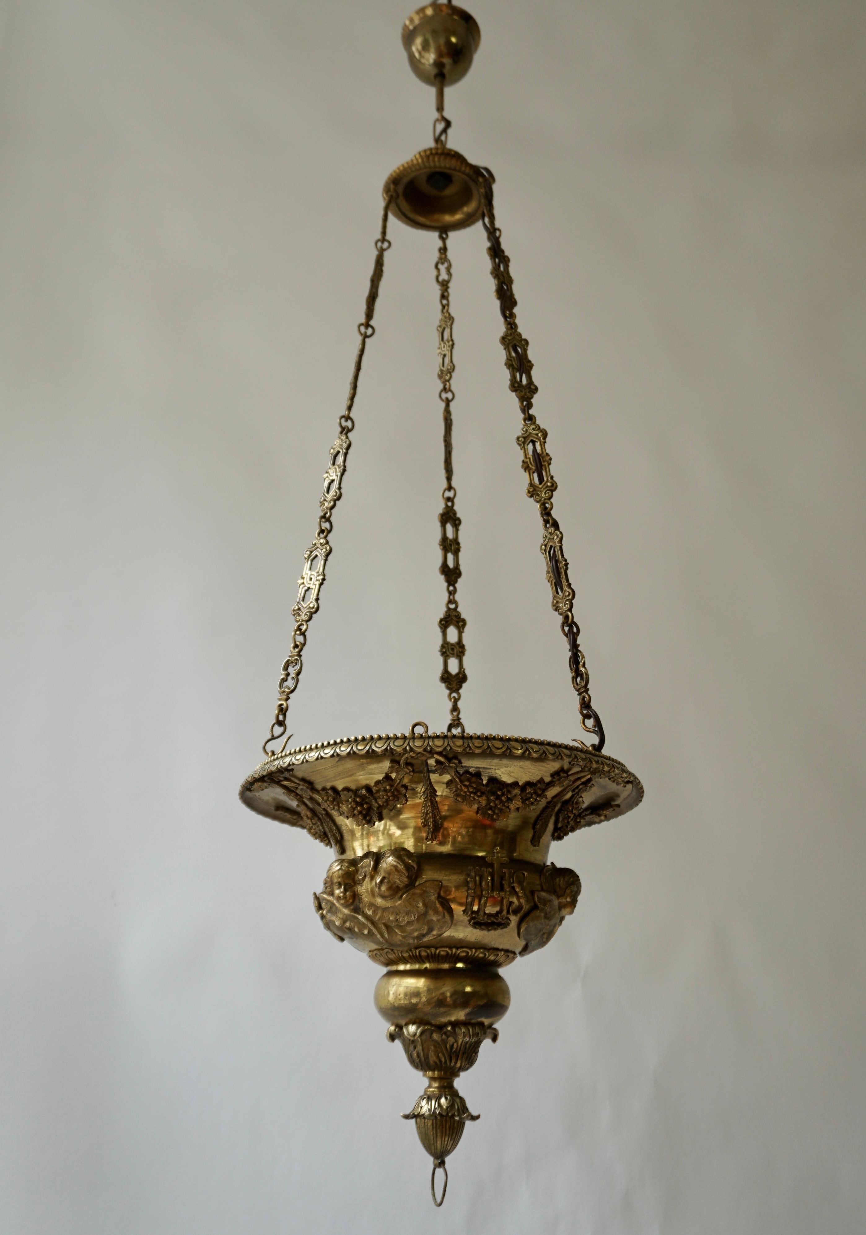 Eine barocke Altarlampe oder Weihwasserschale aus gehämmertem gelbem Kupfer. Verziert mit geflügelten Engelsköpfen und Traubenranken.

Gesamthöhe 49