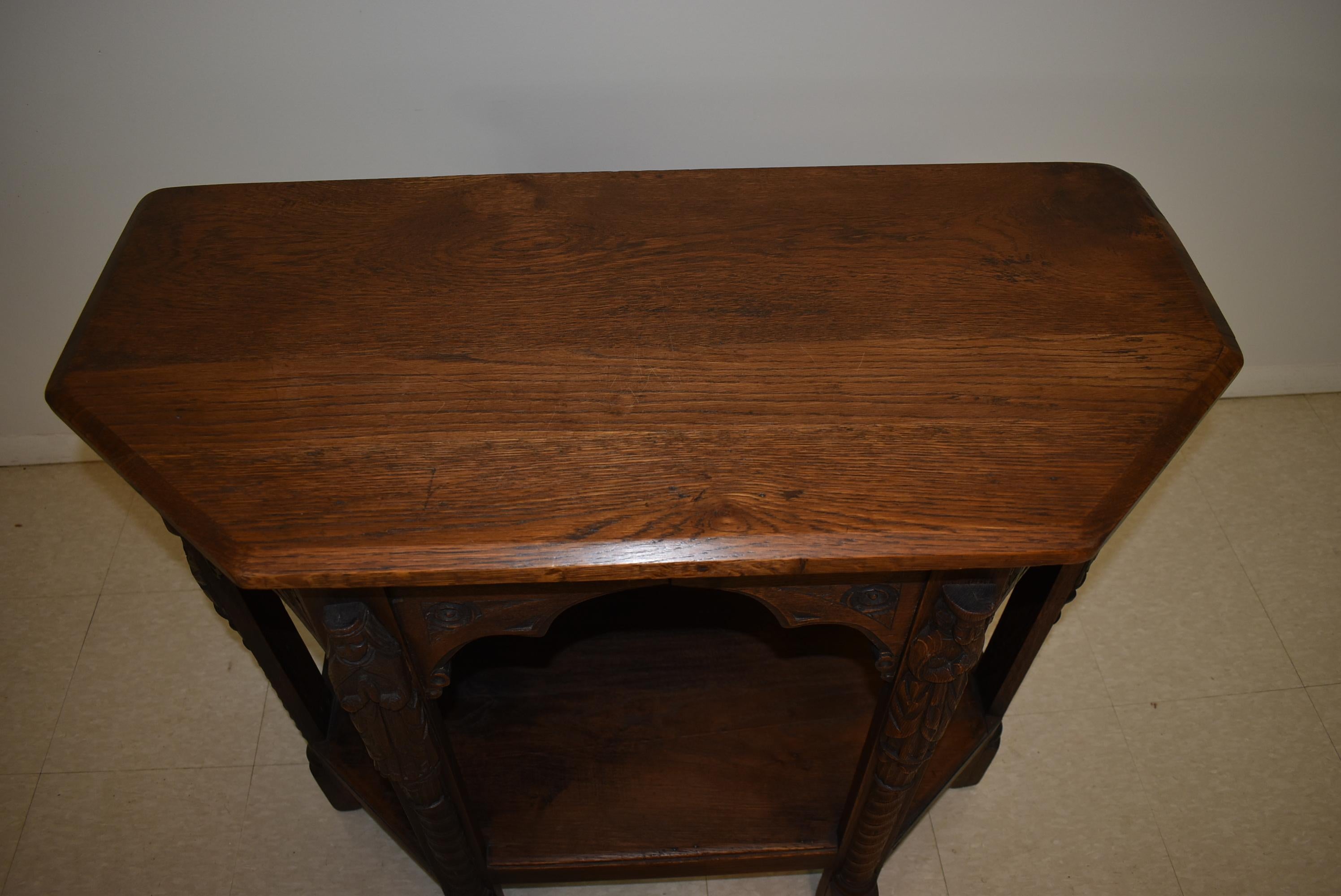 Handcrafted antique Gothic Revival console table. Original finish. Four different hand carved figures.