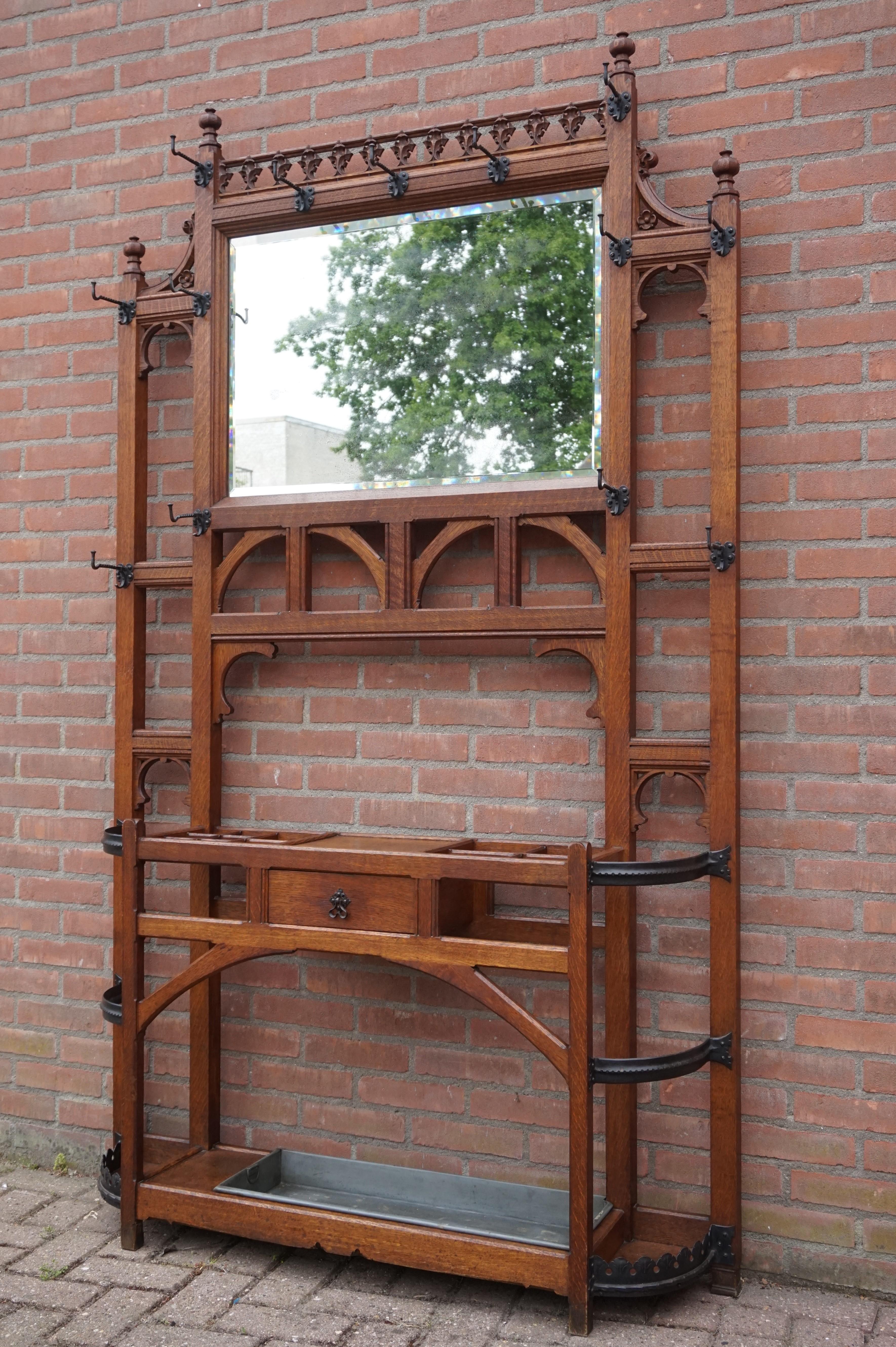 Unique and highly practical Gothic coat rack with cane and umbrella stand and mirror.

This large and beautiful Gothic hall Stand is another great example of the quality of the workmanship in late 19th and early 20th century Europe. Hall stands of