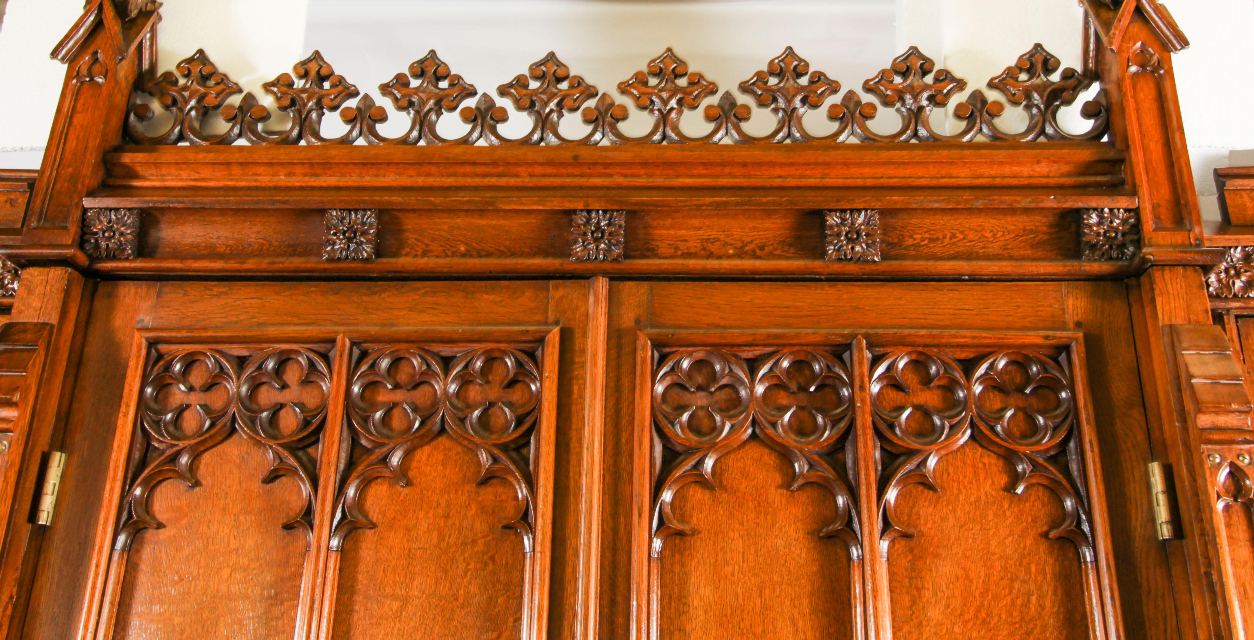 Superbe armoire de style néo-gothique victorien en chêne, à la manière de Thomas King, datant de 1840 environ.
 
La partie centrale, la plus grande, présente un fronton cruciforme alternativement sculpté en C et en volutes, avec des pinacles à