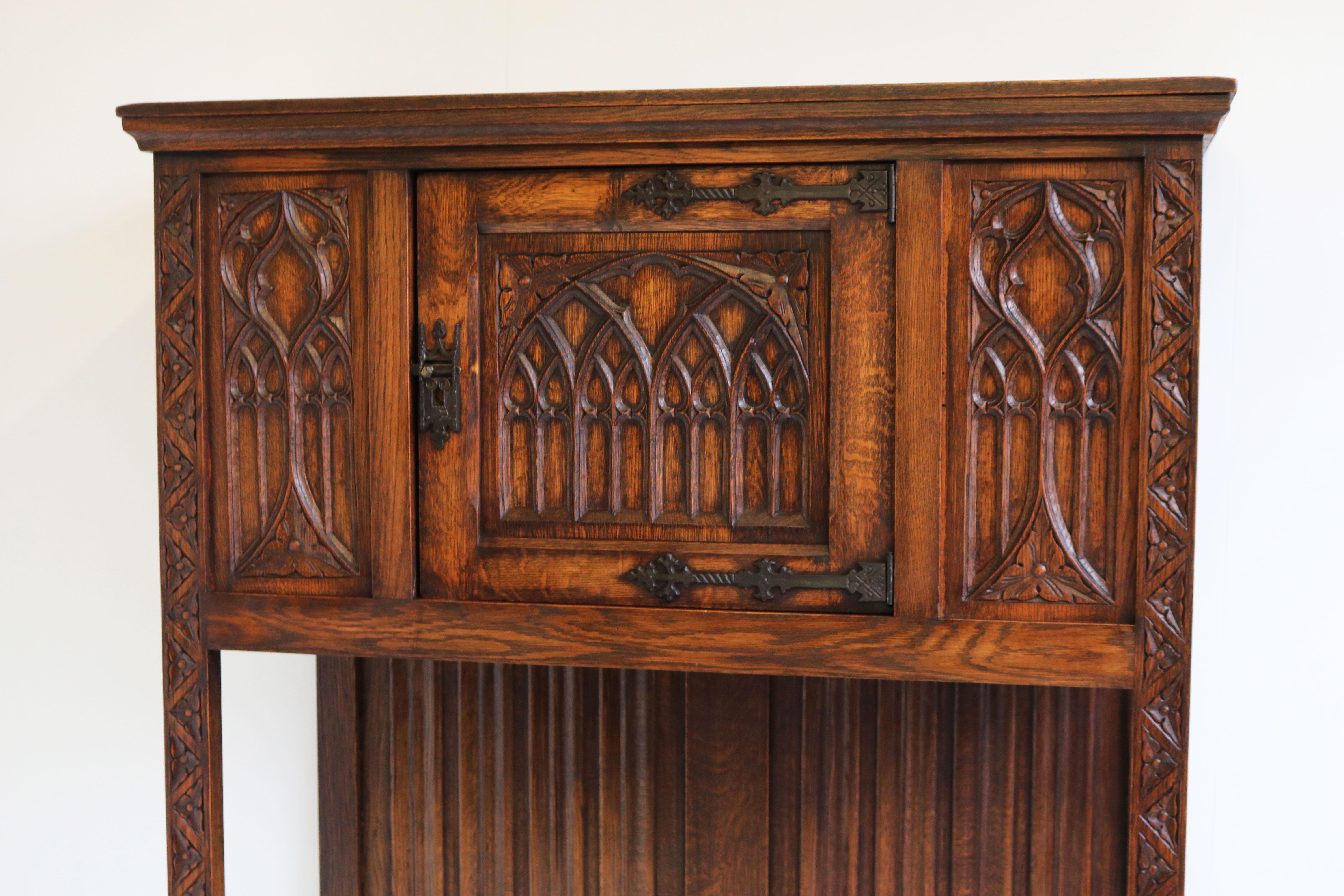 Marvelous & rare ! This Gothic Revival dry bar / drinks cabinet in European oak. 
Gorgeous carved details like church windows, booked panels & Gothic style decorations. 
The door can be used to store your glasses & drinks inside with additional