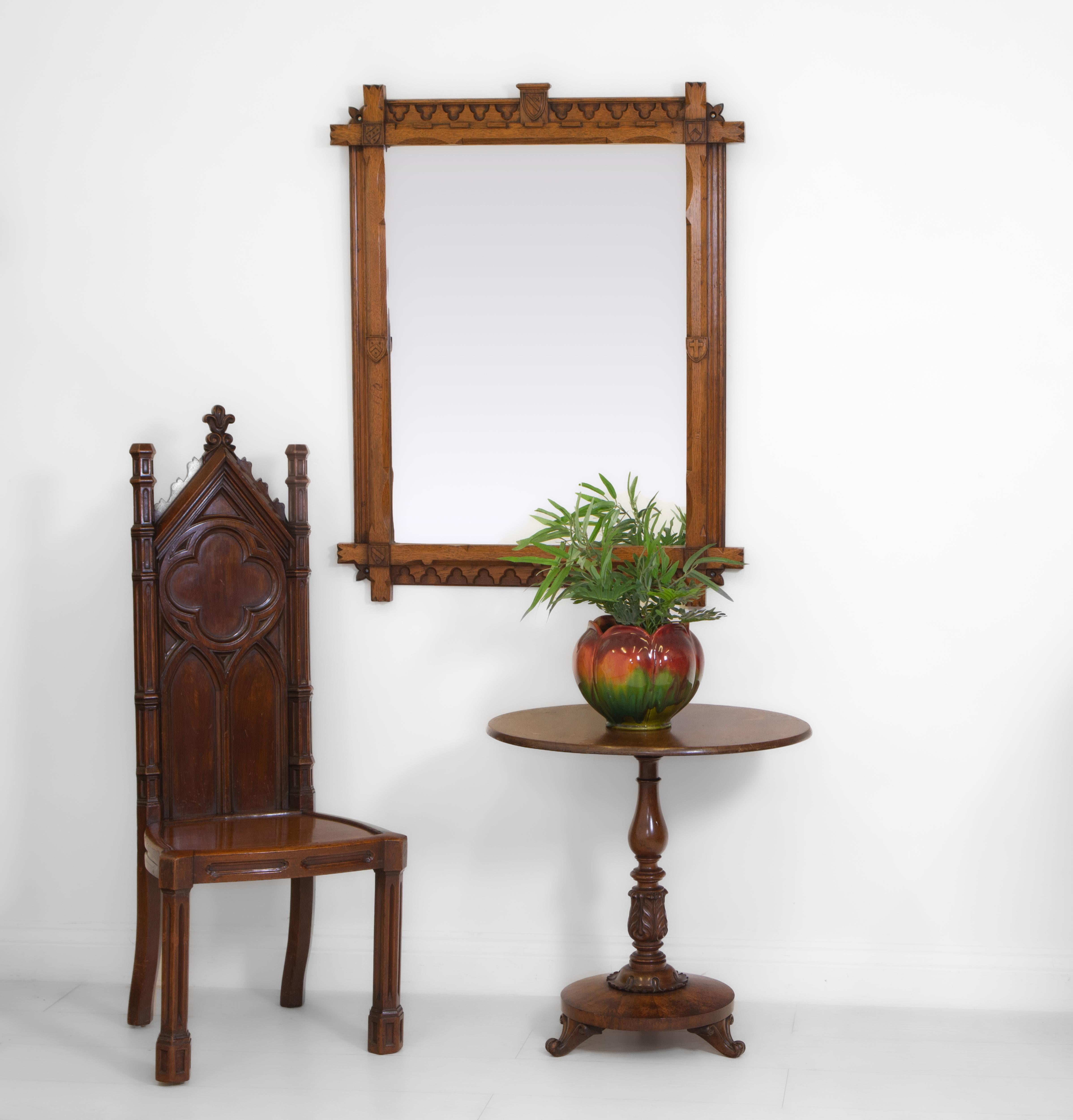 A 19th Century Gothic revival oak wall mirror. Circa 1880.

The oak frame having chamfered edgings with trefoil relief and shield emblems to each corner and central top. Overall in very good condition, a few marks with age and some minor nibbles to