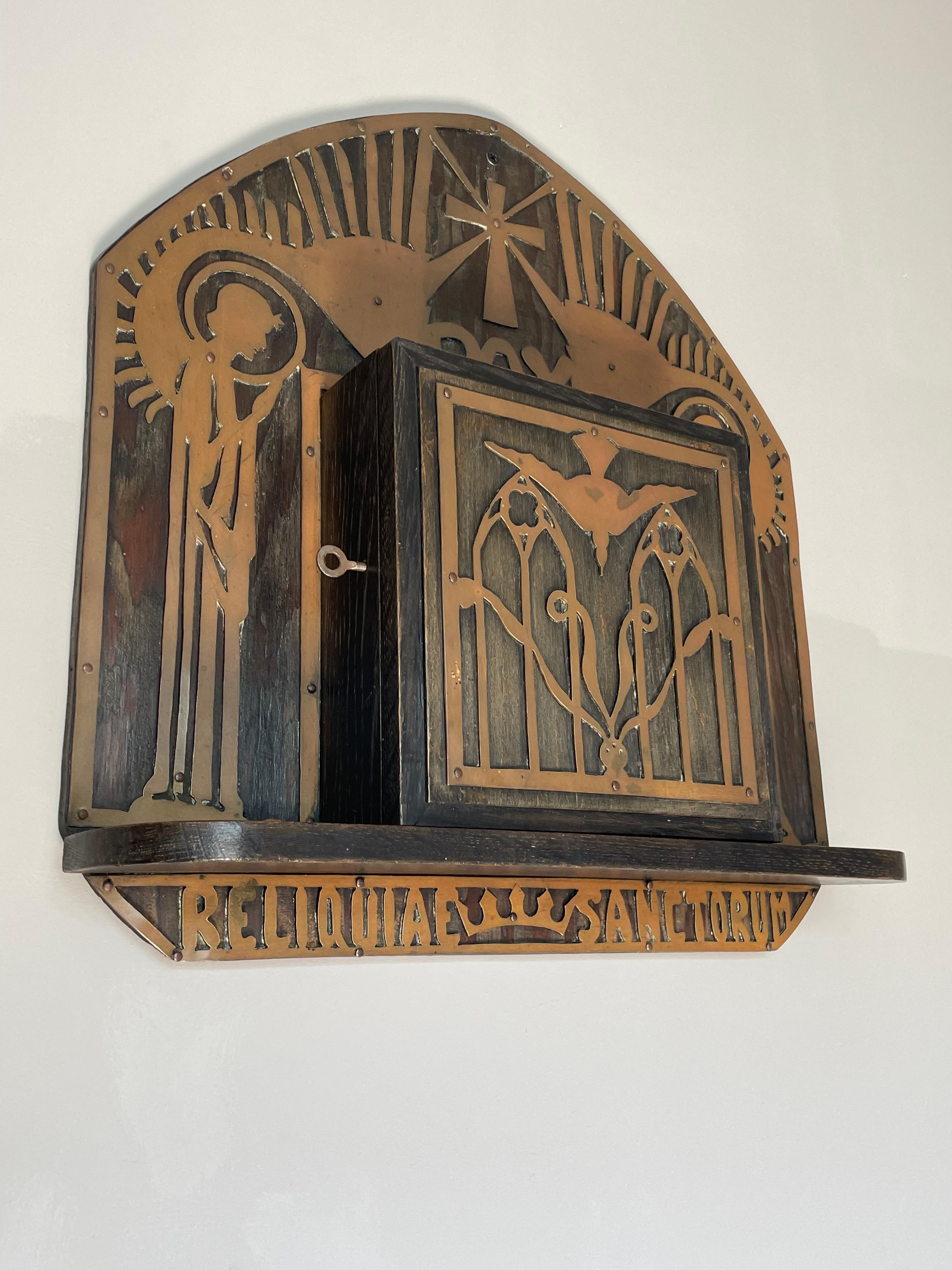 Unique and highly collectible antique Gothic wall cabinet with working lock and key.

This handcrafted and rare Gothic Revival wall cabinet from the late 1800s or early 1900s is another one of our magnificent recent finds. The uniqueness of the