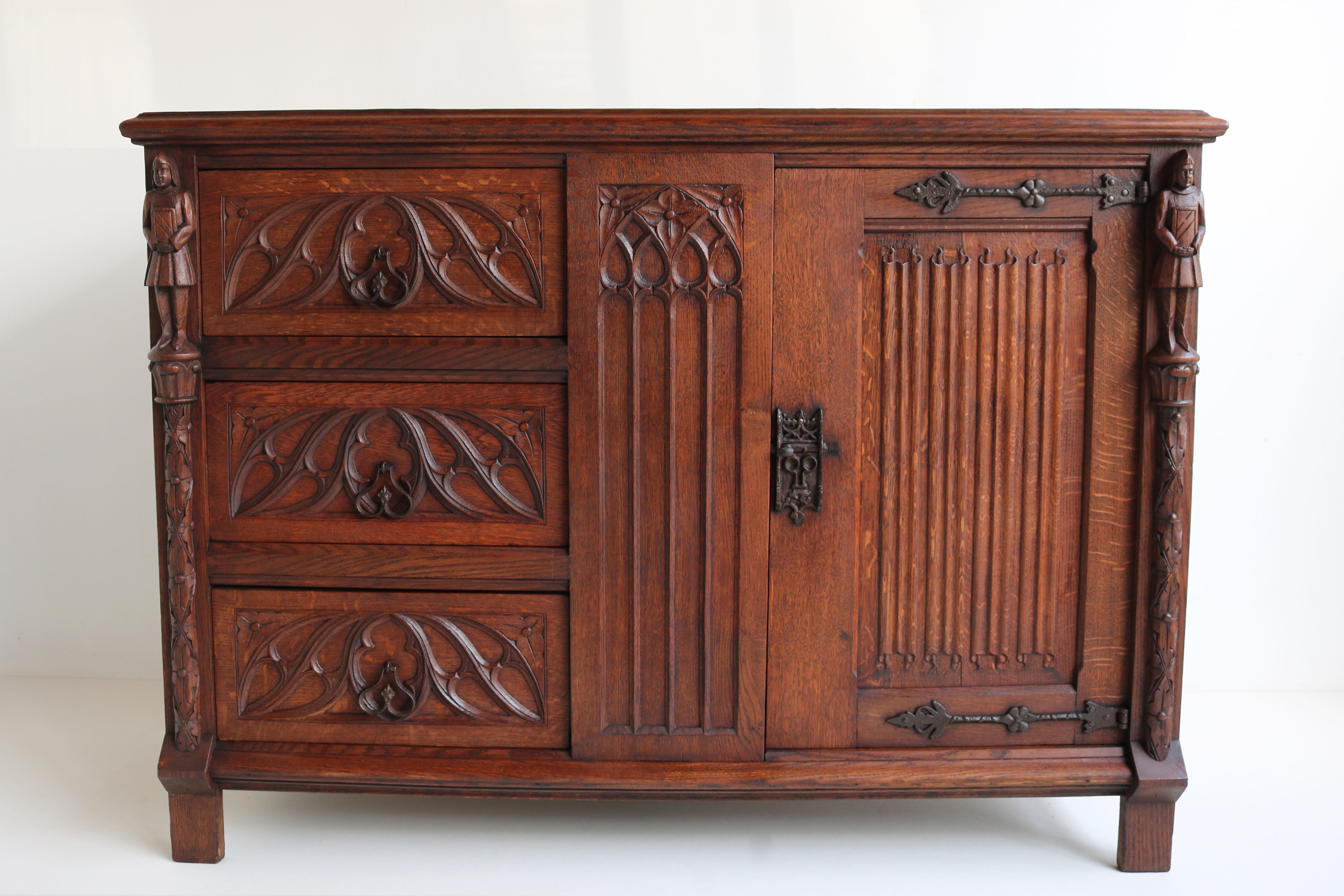 Gorgeous & practical ! This Antique French Gothic Revival Cabinet / Small credenza from the 1920s. 
Made out of hand carved European oak, with marvelous gothic details such as Knights & Cathedral arches. 
Great sturdy quality piece, with plenty of