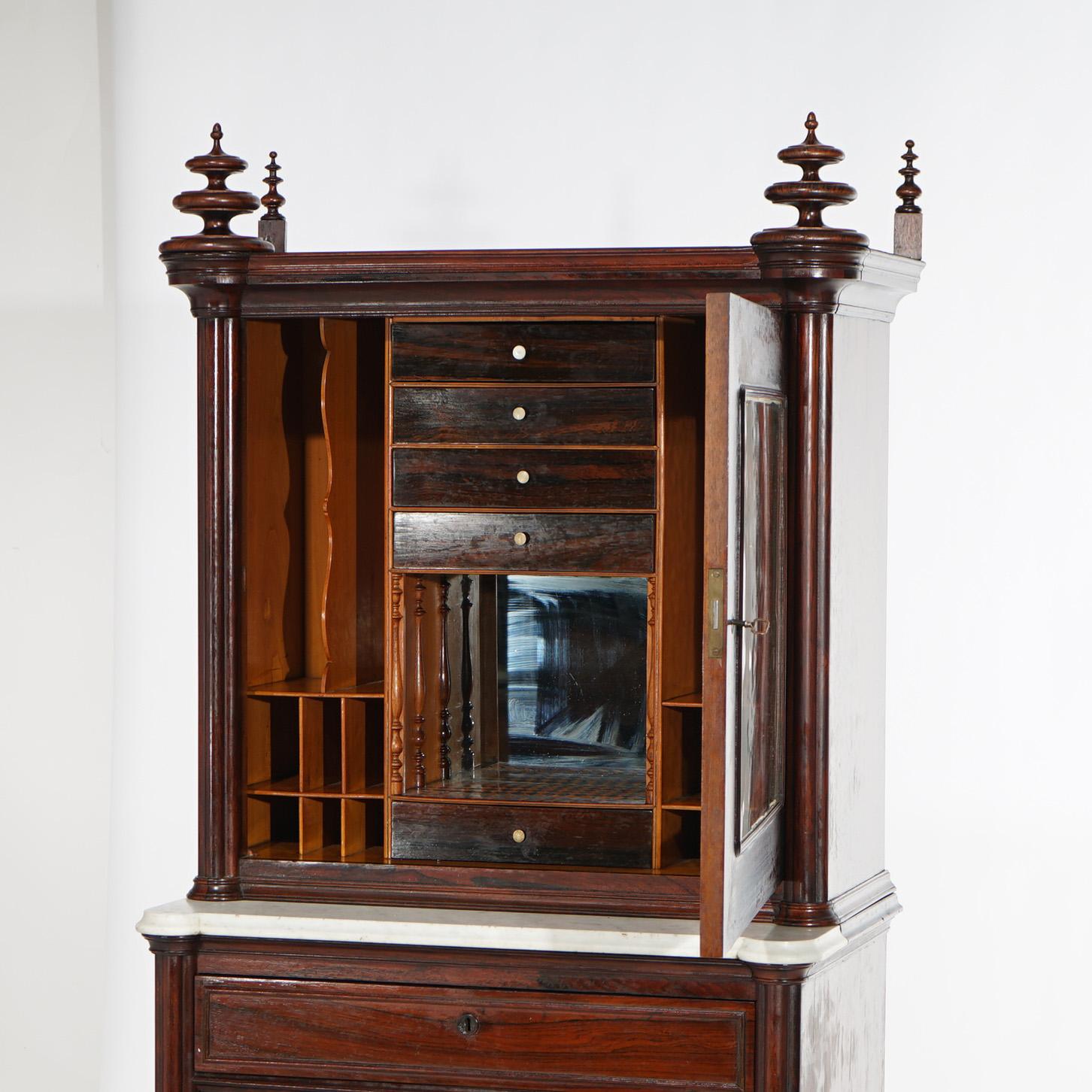 An antique Gothic Revival secretary offers rosewood construction with upper having stylized finials over case with double glass doors opening to mirrored interior with storage compartments over marble top lower case, c1850

Measures- 67.5''H x