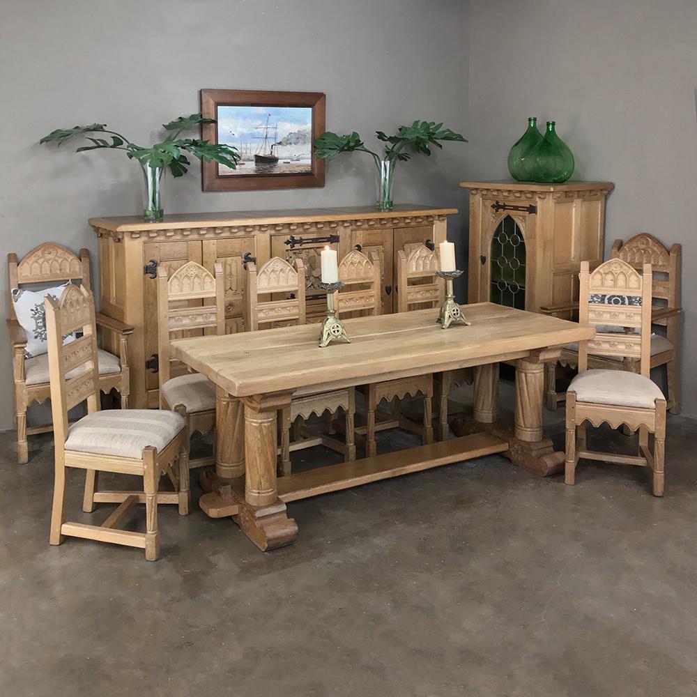 Antique Gothic Rustic Stripped Oak Dining Table was fashioned from thick timbers of solid oak to last for centuries! Subtle Gothic influence in the carvings of the legs provides just the right Old World masculine touch, with a full shimmed trestle