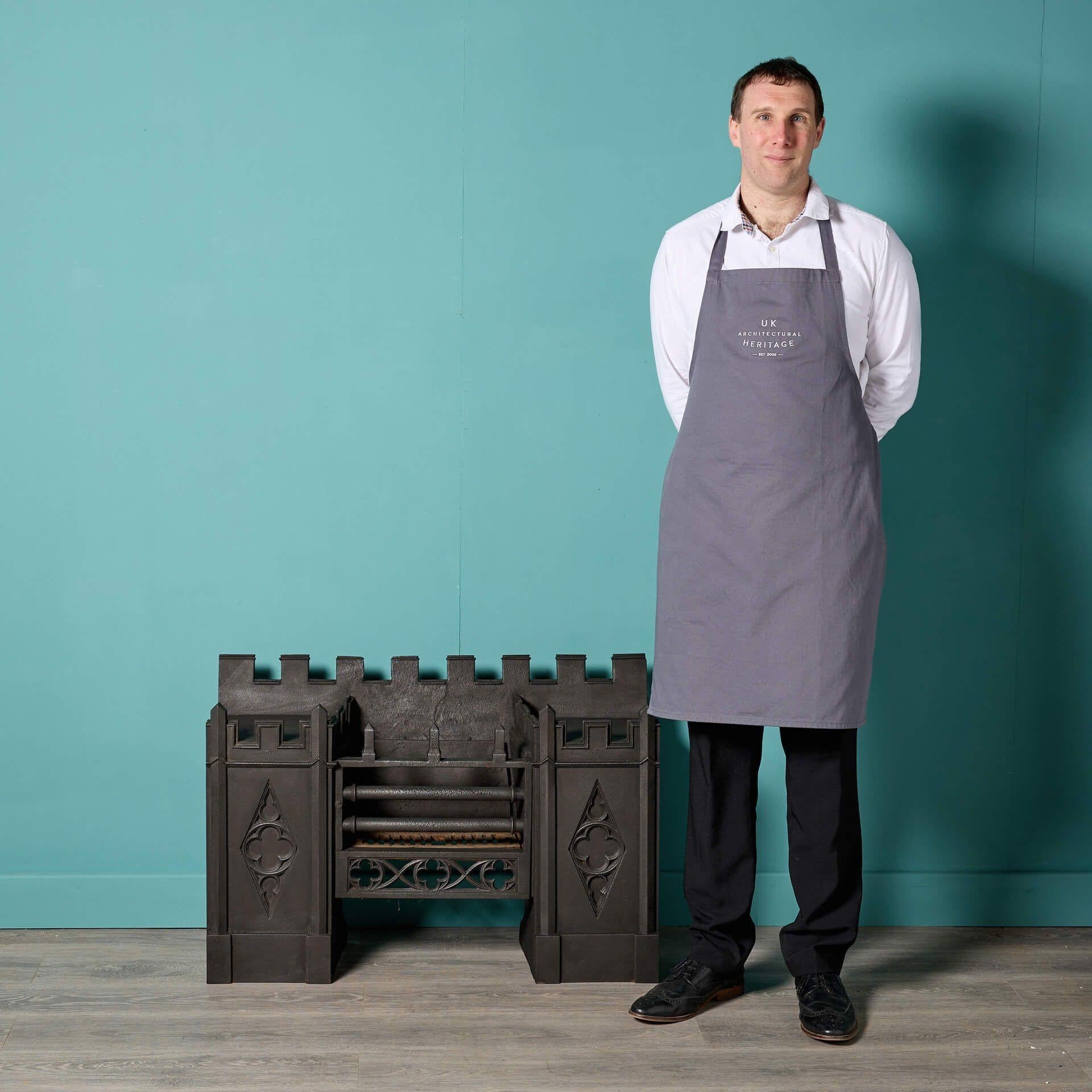 Rejilla de cocina de estilo gótico de la época victoriana que data de hacia 1830 y está inusualmente decorada con almenas y cuatrifolios. Acabada en negro grafito pulido, esta antigua parrilla de hierro fundido dará carácter a una chimenea moderna o