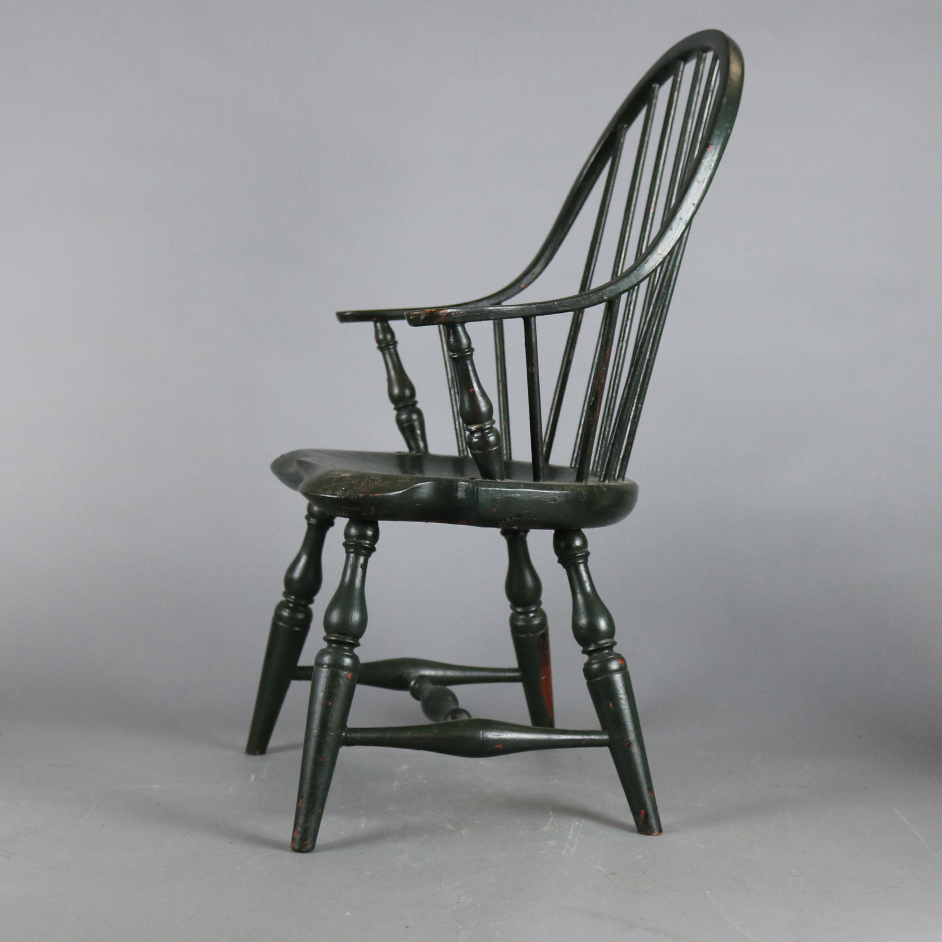 An antique bow back Windsor child's armchair offers spindle back with continuous arm over seat raised on turned legs, grain painted, 20th century.

Measures- 26.5