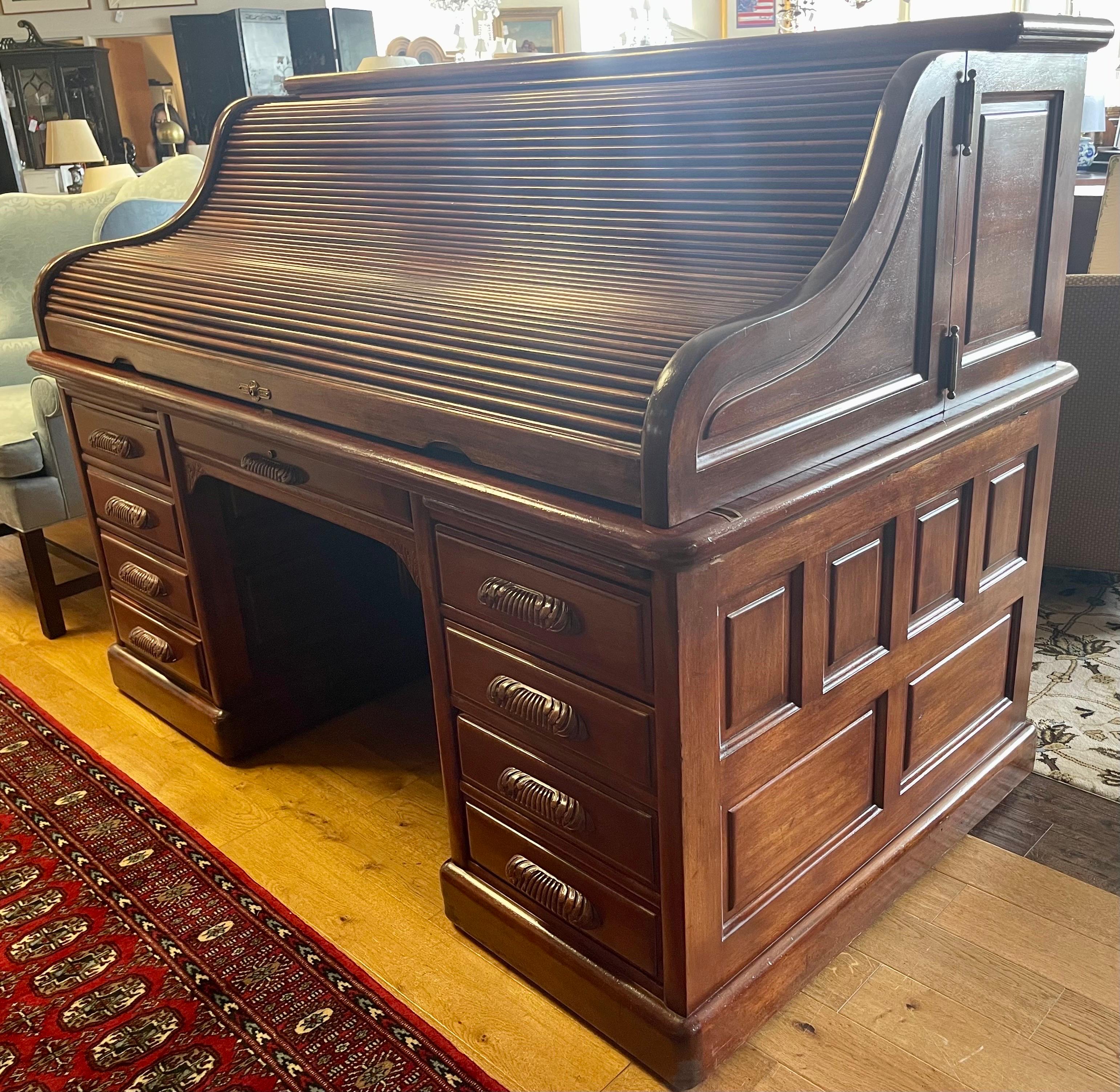 Rare and coveted signed Derby desk, the big one, by Derby Desk Company, Boston, Ma circa turn of the 20th century. This grand mahogany roll top desk features S roll top with hinged wings, 19 drawered interior, raised panels and carved pulls, marked