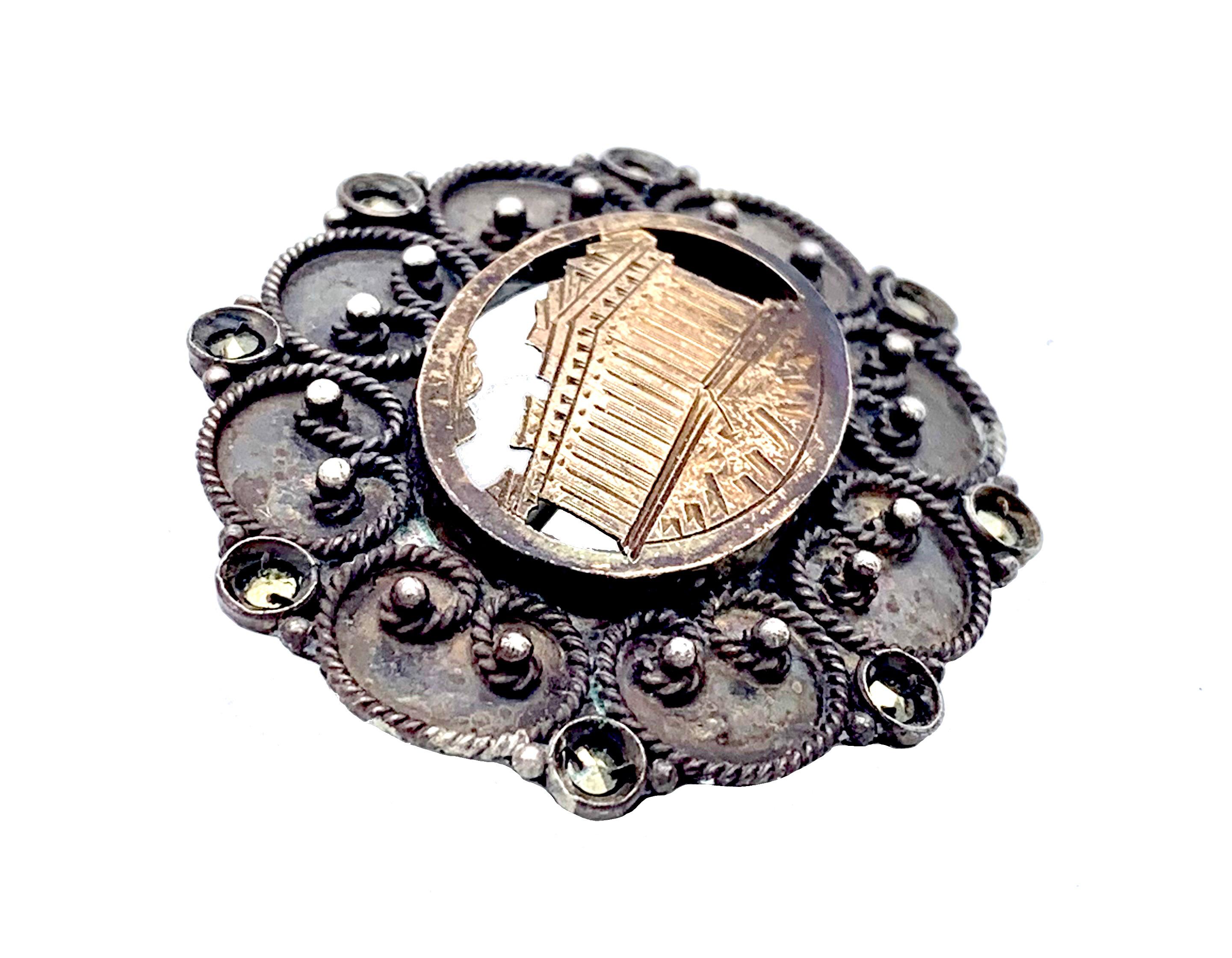 This unusual brooch features a typical Greek Grand Tour image, that of the Acropolis and the Parthenon.  In an oval frame we see the cut out silver gilt image of parts of the Acropolis, the Parthenon and a few clouds, highlighted in rose gold