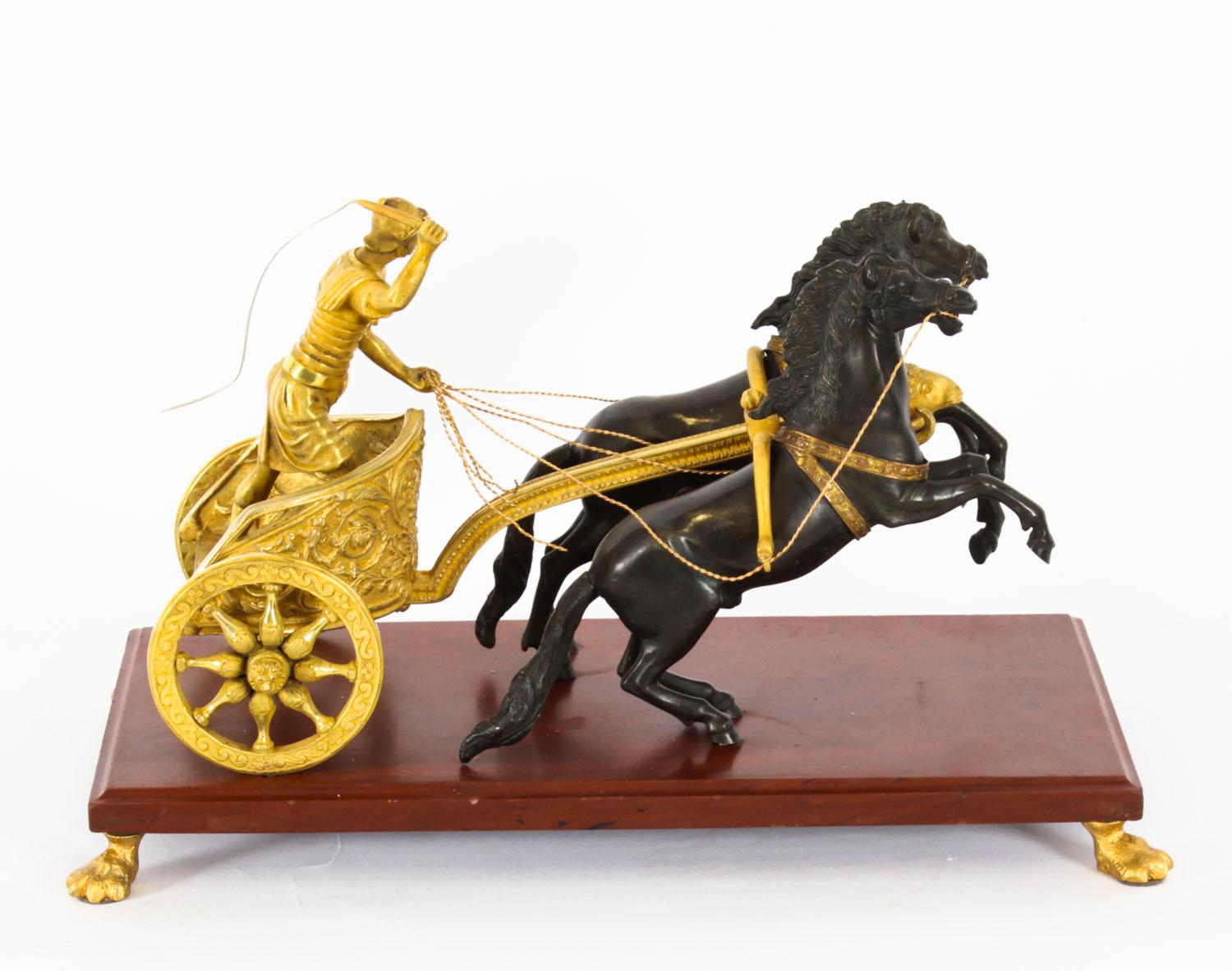An elegant antique French Grand Tour gilt and dark patinated bronze group of an Ancient Greek chariot, dating from the early 19th Century.
 
The finely cast sculpture features a gilded ancient Greek charioteer racing a pair of dark patinated bronze