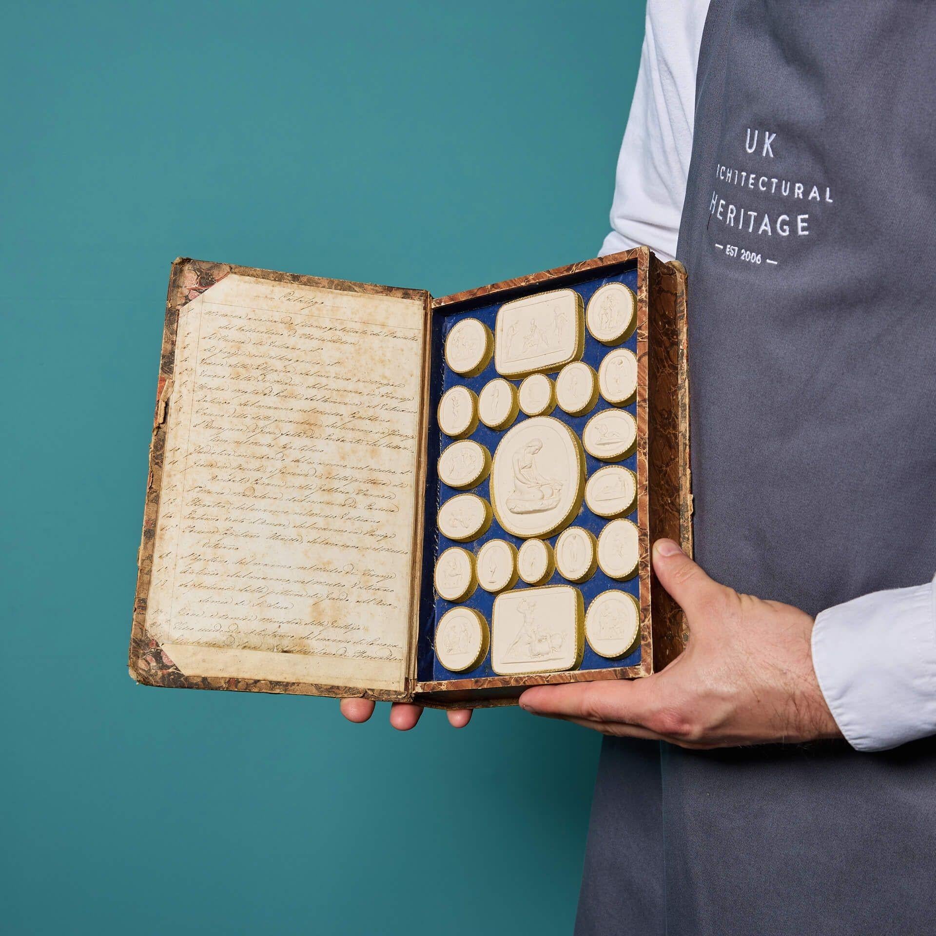 An antique Grand Tour faux book of plaster intaglios by Pietro Paoletti (1801-1847).

This intriguing book encloses thirty-eight classically themed Italian medallions surrounded by a gilt border on a deep blue background between two handsome