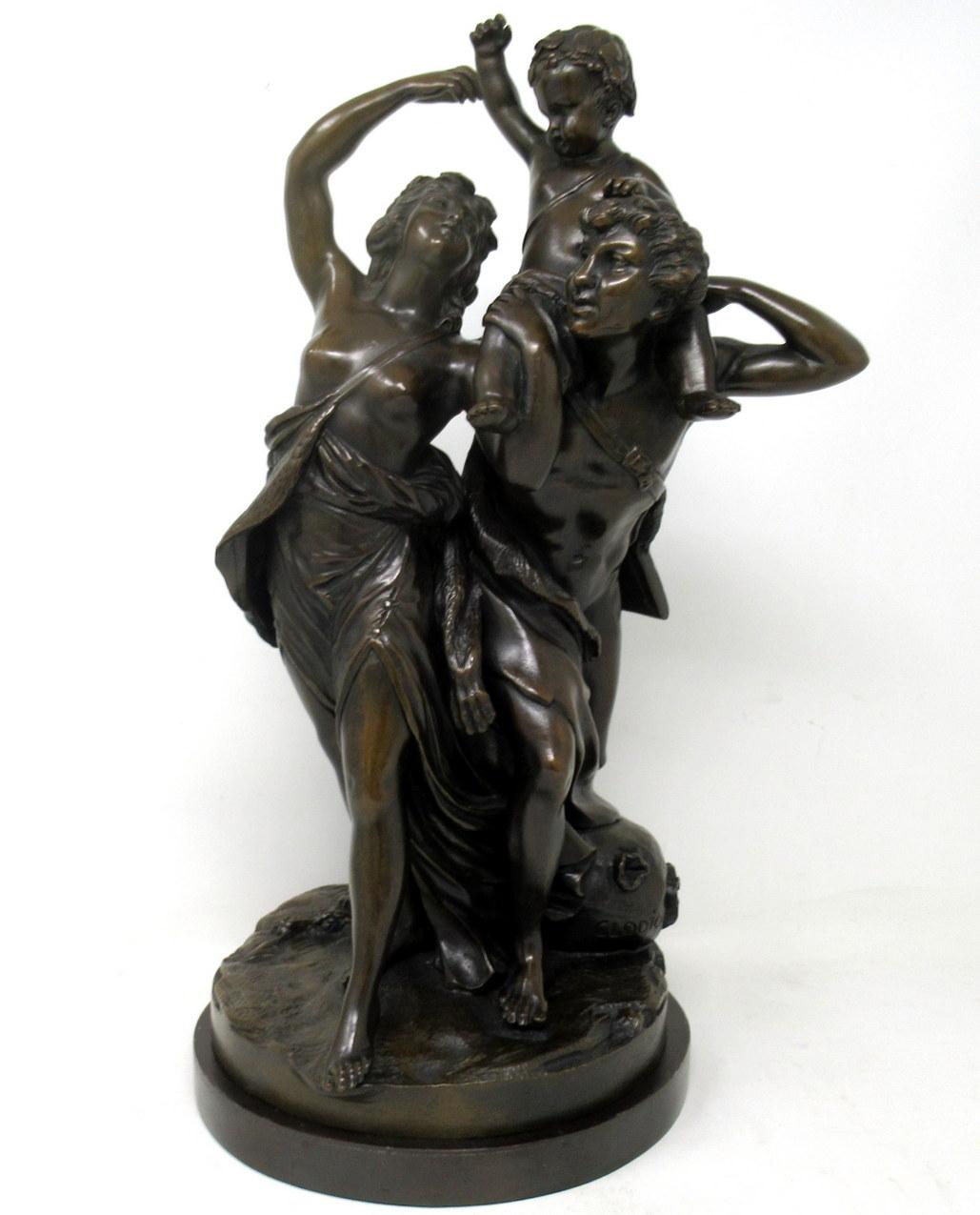 An exceptional example of a chisel cast French Patinated Bronze Figural Group of a Satyr and a male Figure holding a Baby Bacchus after Claude Michel Clodion (1738-1814) in dark patination offered complete with its original circular bronze stepped
