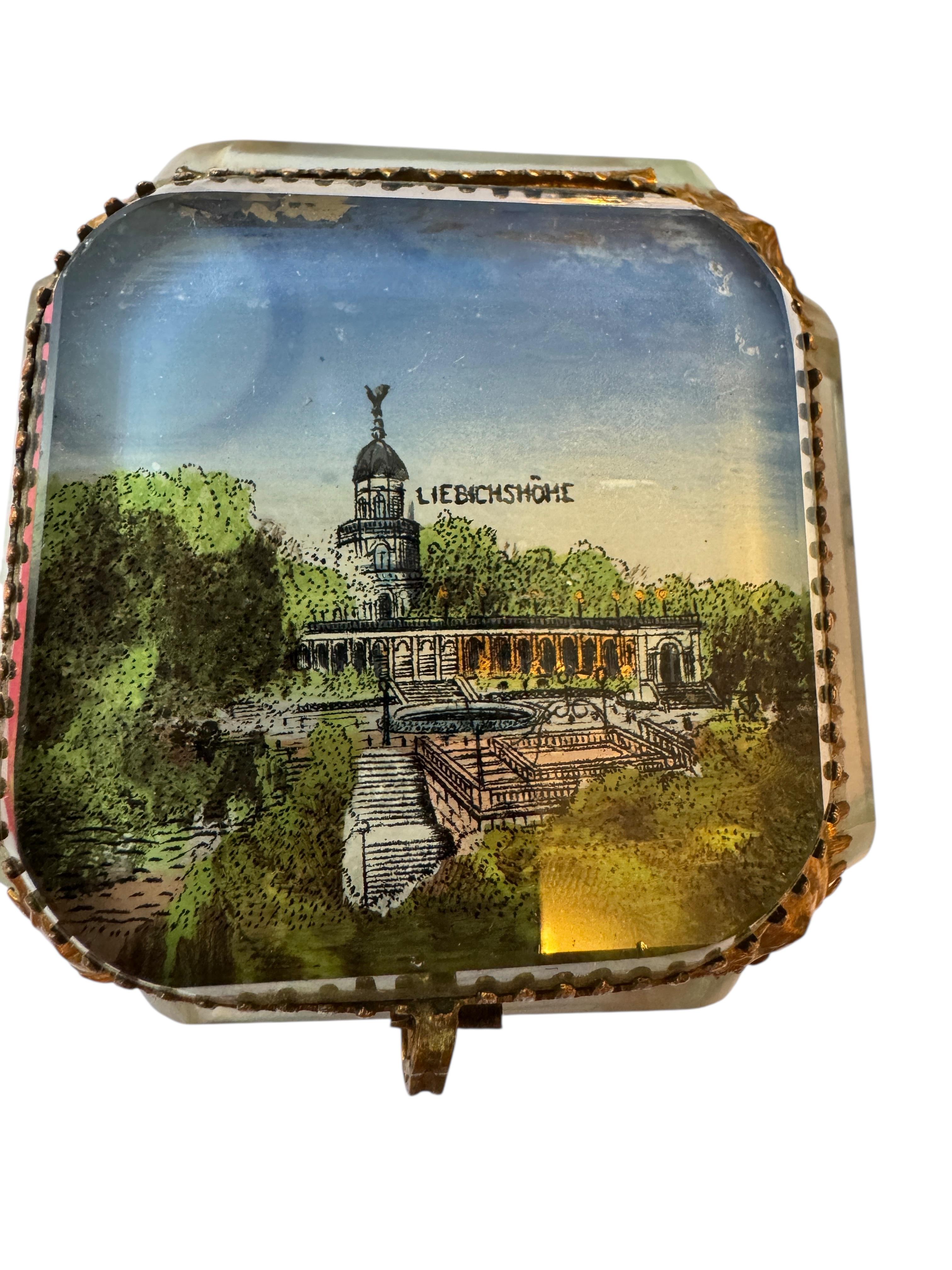 Antique Ormolu and Églomisé Casket - Souvenir from Breslau, Poland circa 1900

A charming antique casket from circa 1900 with gilt brass fittings and clear glass panels. The hinged lid features beveled glass, painted on the reverse (Églomisé),