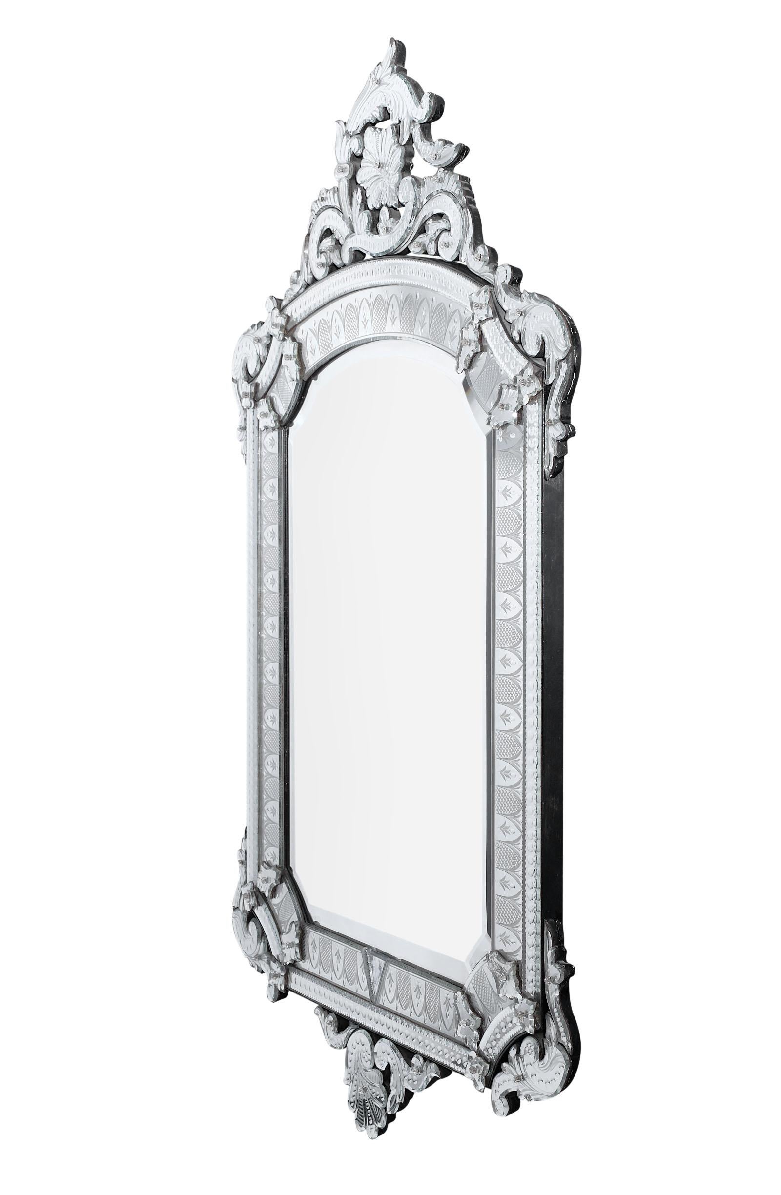 Antique grand Venetian mirror with rich and intricately engraved decor. This complete piece is in excellent antique condition!