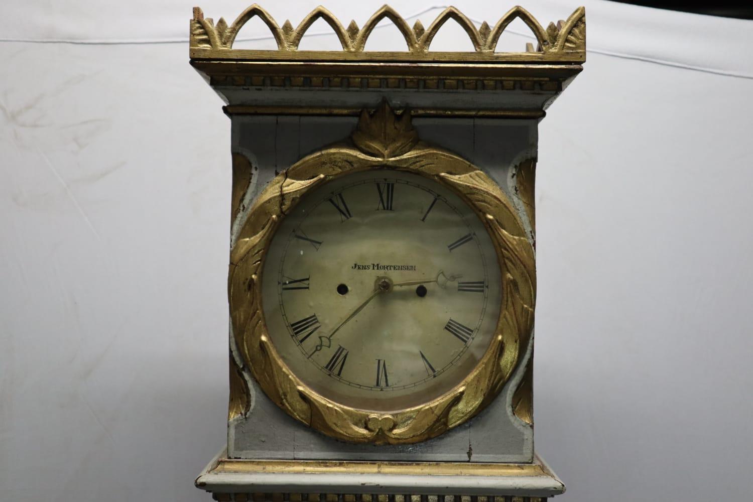 This stately Grandfather clock is from the first quarter of the 19th century. It is made in the traditional Scandinavian style of clock making and has charming and whimsical details on the face of the clock as well as filigreed wooden side access