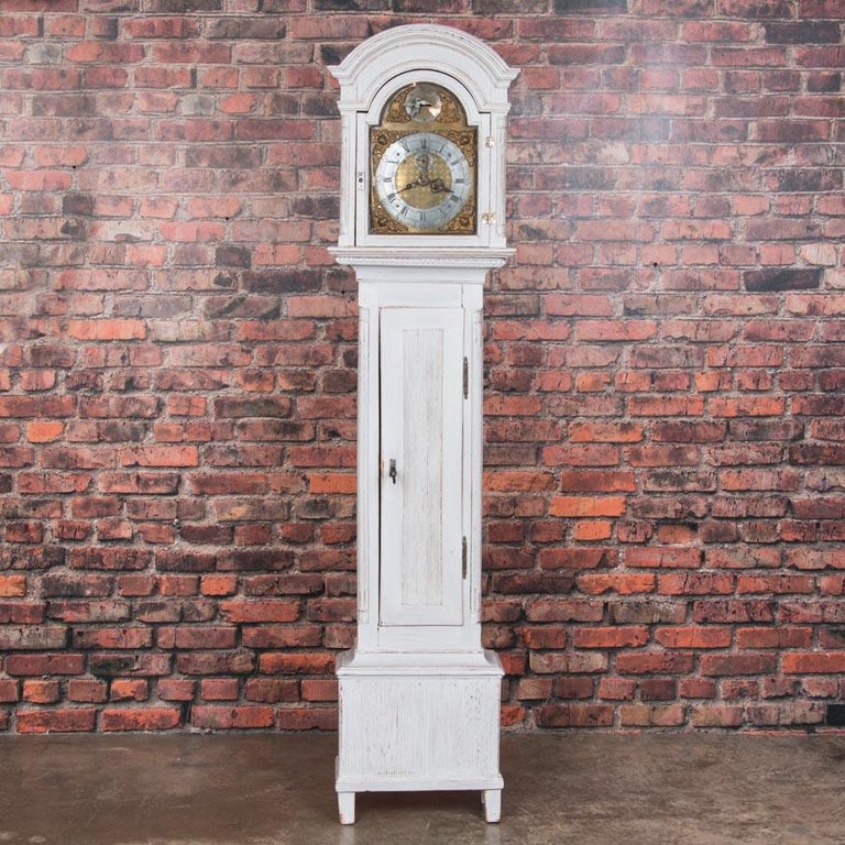 This charming Danish grandfather clock was crafted in the traditional early 19th century Scandinavian style. The new, light gray paint is slightly distressed creating the perfect contrast with the darker pine underneath and enhancing the delightful