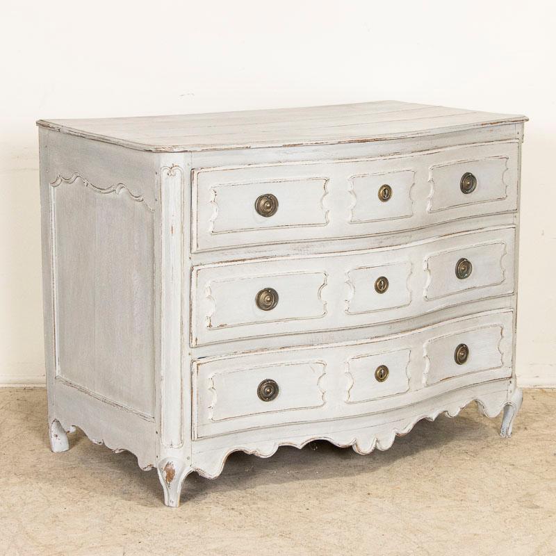 The soft gray paint adds a romantic touch to this serpentine oak chest of drawers. While the paint was added later, the carved panel drawers, curved front, cabriolet feet and scalloped skirt are gently distressed adding to the vintage feel of the
