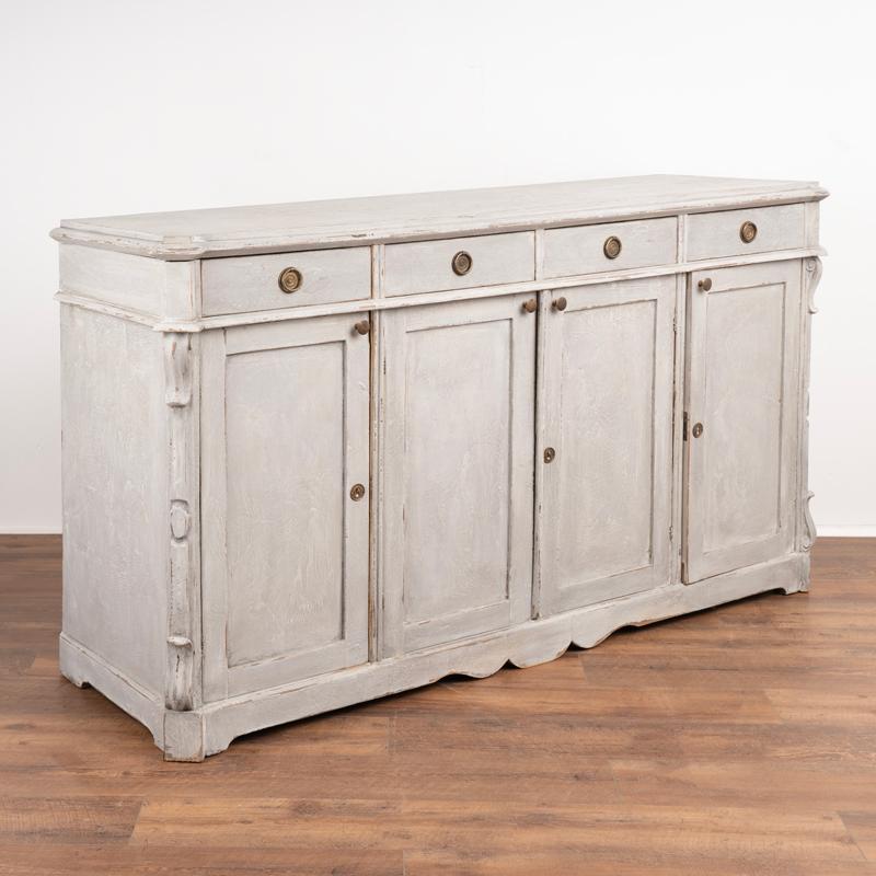 Swedish sideboard/buffet in gray painted pine wood.
Top with profiled edge.
Four drawers over four cabinet doors, interior shelving.
Restored, later professional painted in gray/white layers and gently distressed to fit age of sideboard.
Please