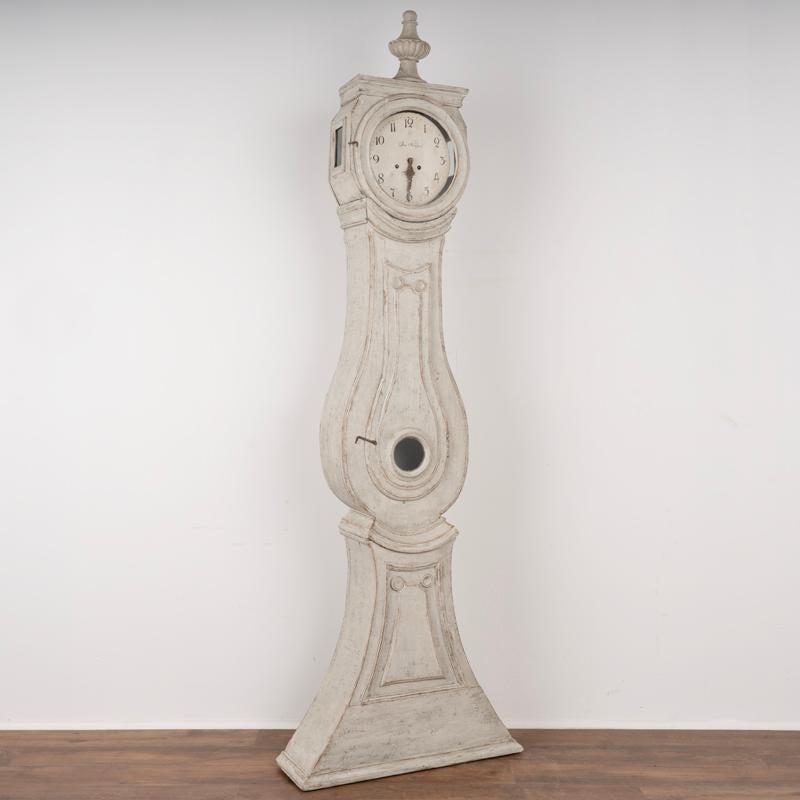 Antique Swedish Mora Grandfather Clock. Carved panel details and crowned with large finial. 
Newer professionally applied white and gray layerd finish, lightly distressed to fit age of clock.
Original clock face and hands.
Clockworks do not
