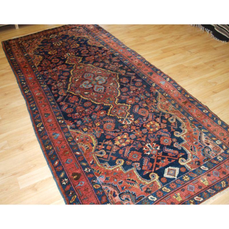 Antiker Kelleh-Langteppich aus dem Großraum Hamadan mit einem großen, länglichen Einzelmedaillon, umgeben von einer großformatigen Variante des Heratti-Musters.

Dies ist ein sehr schöner Teppich, das großflächige Muster ist wunderschön gezeichnet