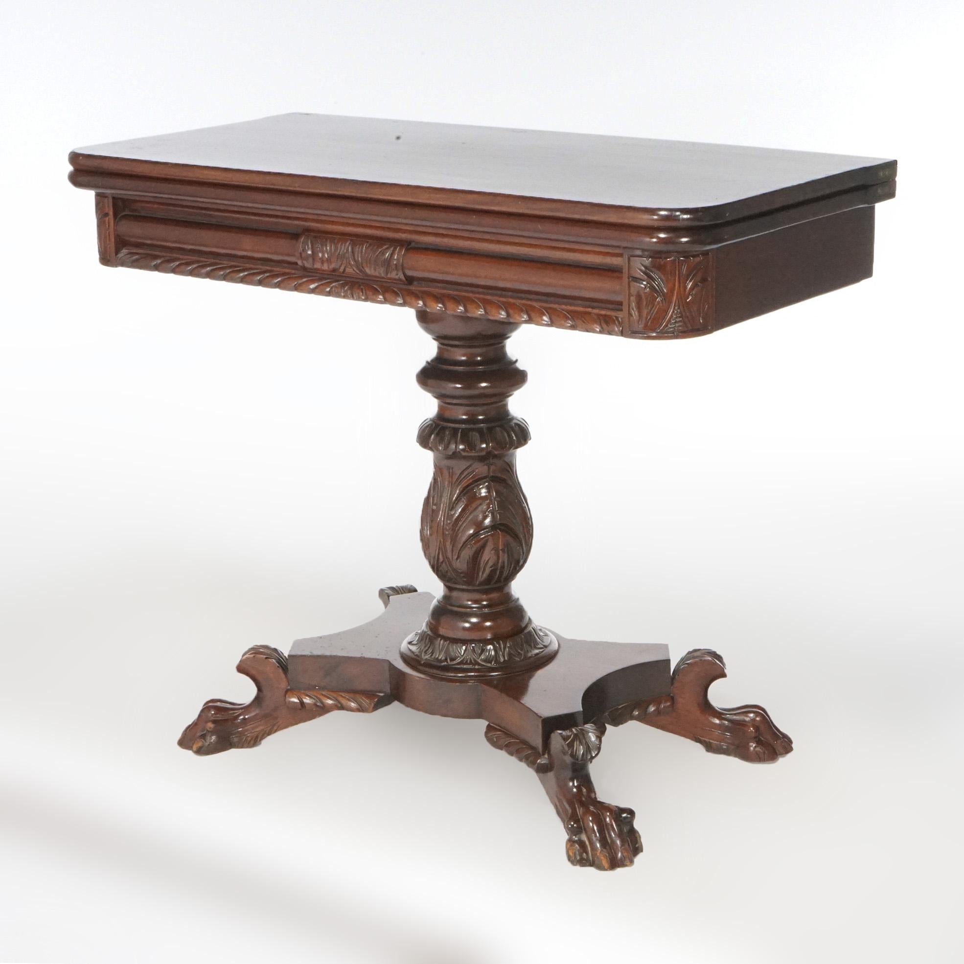 An American Empire Classical Greco game table offers mahogany construction with gadroon trim over urn form pedestal with carved acanthus elements, raised on carved paw feet, c1840.

Measures- 30''H x 35.5''W x 18''D closed; 35.5''D open.