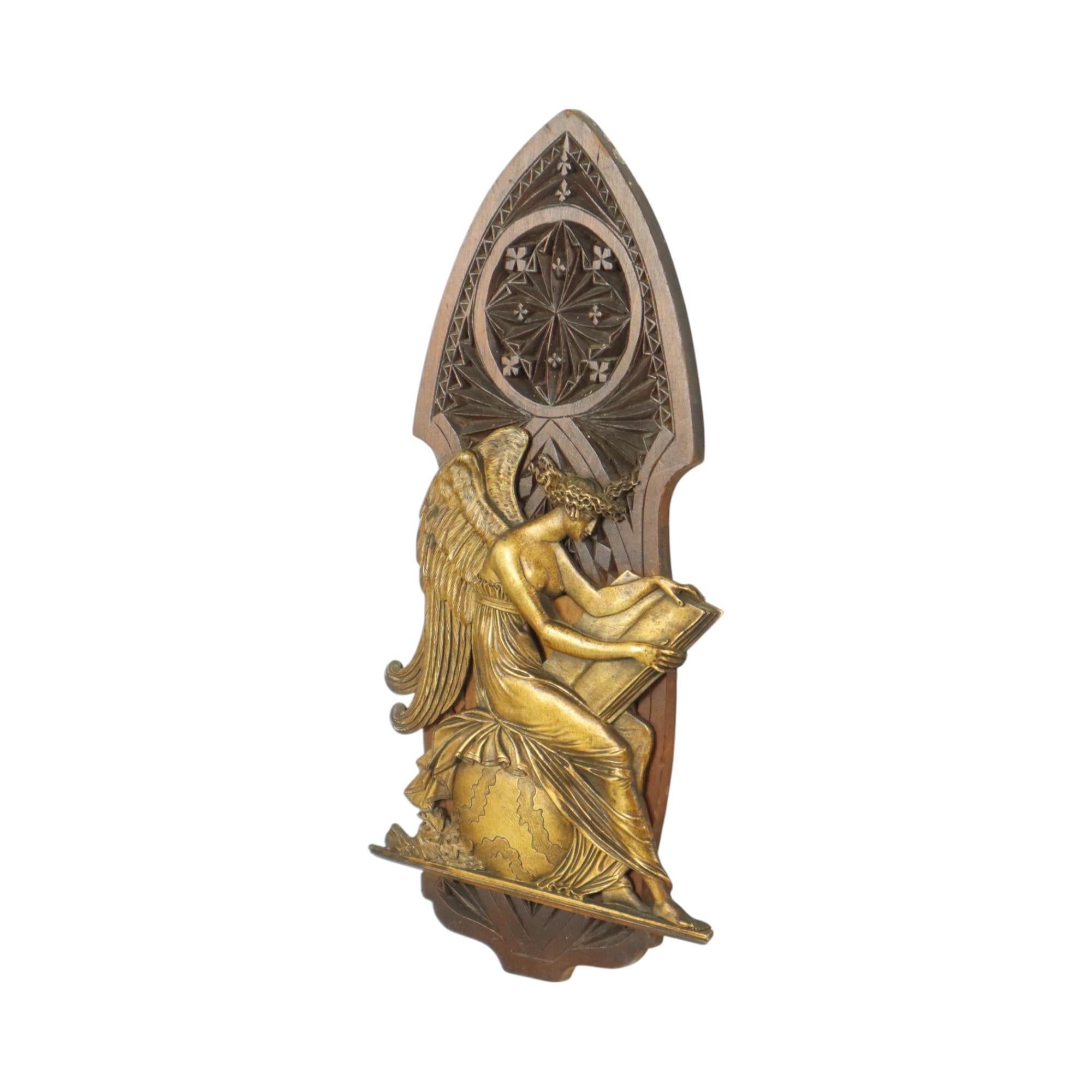 Beautiful antique gilt bronze plaque in bas relief of a Greek goddess depicted with wings, probably the goddess Clio, the plaque is mounted on a hardwood carving in neo-Gothic revival style, second half of the 19th century, circa 1880-1900, not