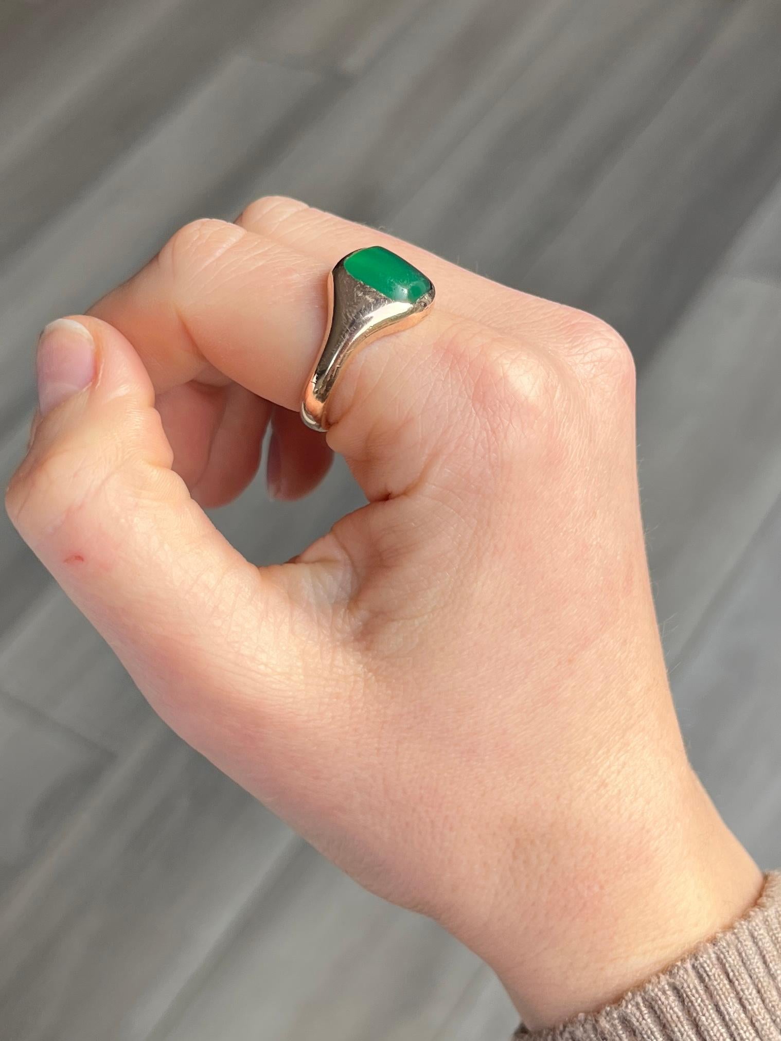This gorgeous Charles Green & Sons signet ring holds a glossy bright green agate in a smooth gold setting. Fully hallmarked London 1923 and modelled in 9ct gold. 

Ring Size: T or 9 1/2 
Stone Dimensions: 10x11mm 

Weight: 7.6g
