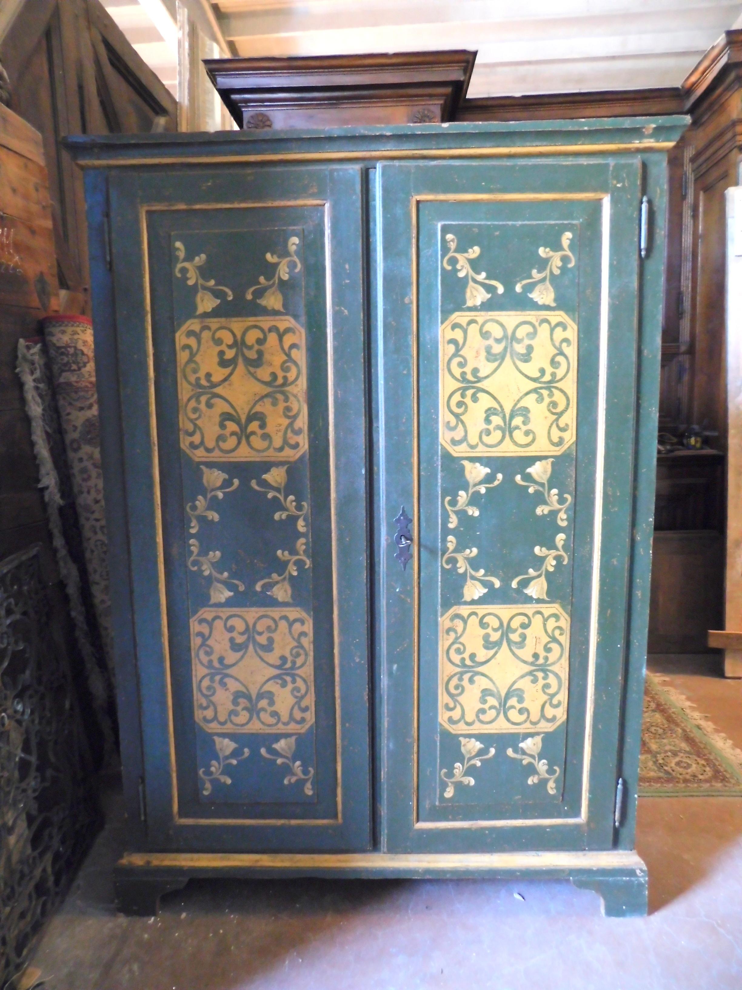 Antique lacquered and painted wardrobe with green background and typical yellow decorations, hand-built in the 19th century, from Piedmont (Italy), has double door with original lock, also painted on the side, solid wood, very well finished and