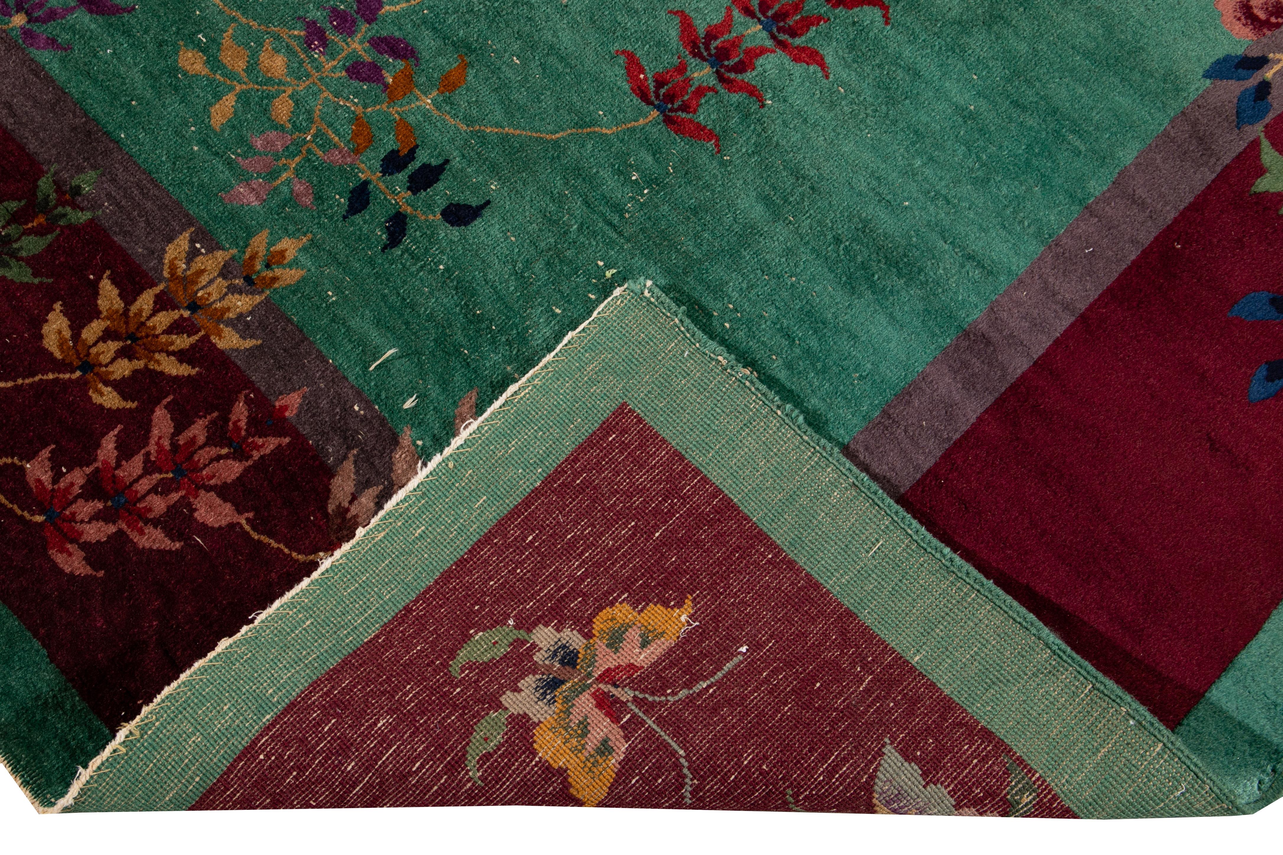 Eine schöne antike Art Deco chinesischen handgeknüpften Wollteppich mit grünem Feld. Dieser Teppich hat einen Rahmen aus roten und mehrfarbigen Akzenten in einem prächtigen chinesischen Blumenmuster. 

Dieser Teppich misst 9'1