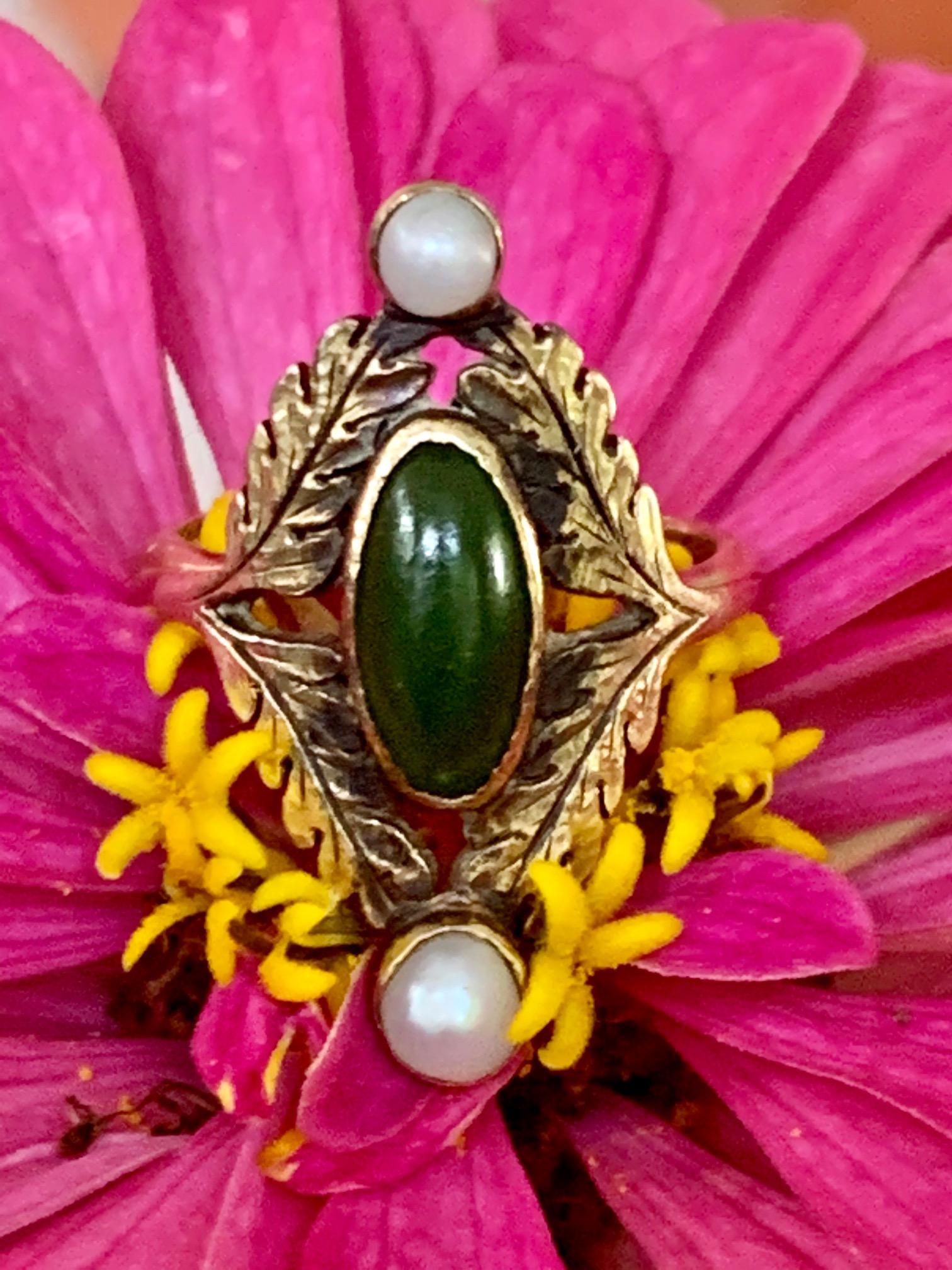 This beautiful antique ring features one green jade cabochon measuring 10mm x 5mm.  There are two pearls accepting the Jade stone.  They measure 3.5mm in size.

Size: 4 -  -This ring can be resized, but G. Lindberg Jewels does not provide sizing