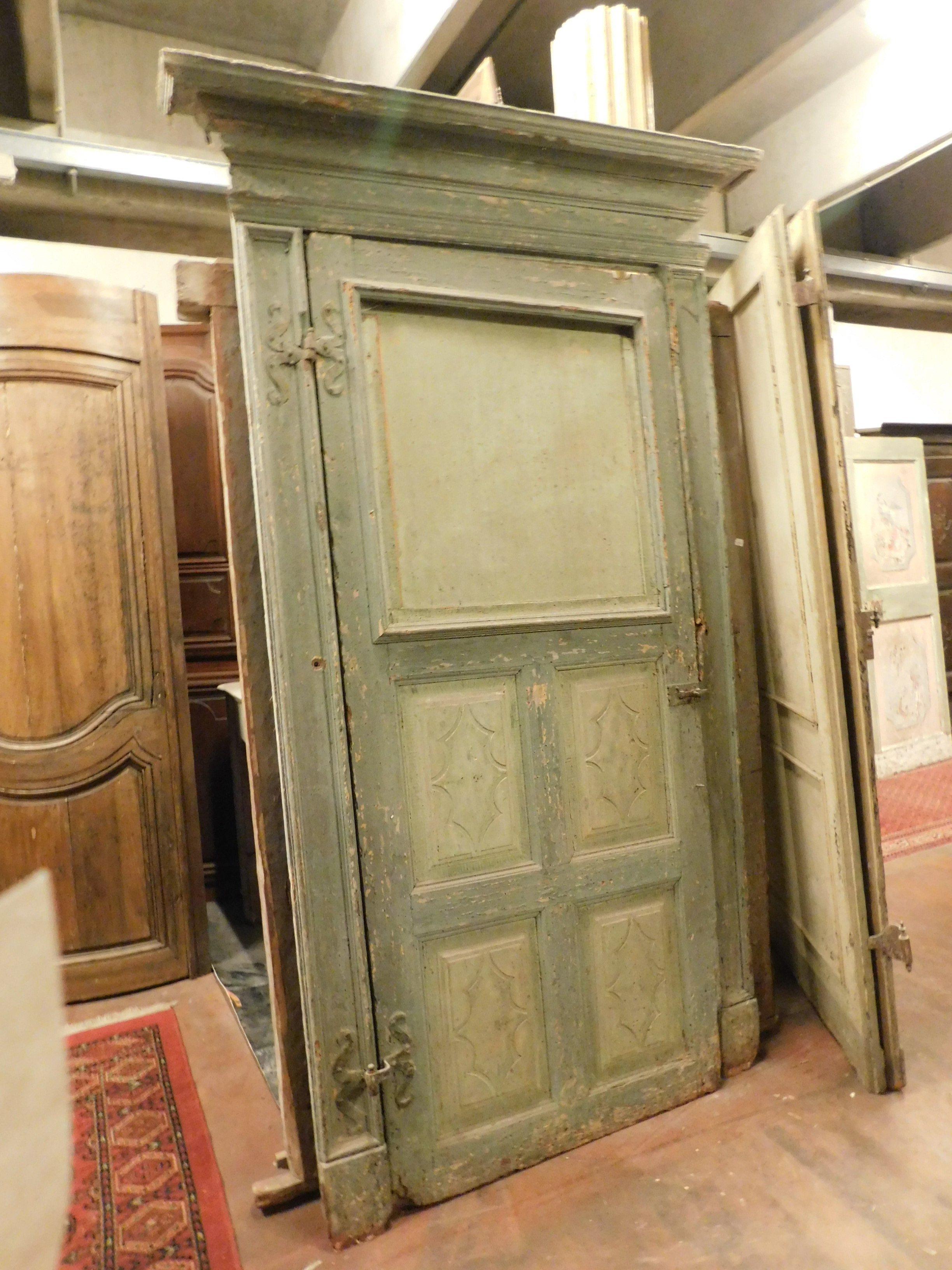 Ancient lacquered door with series of greens and with carved internal panels, original and very beautiful frame and irons, to be conservatively restored but with a patina and beautiful colors. It is from the 18th century, coming from an Italian