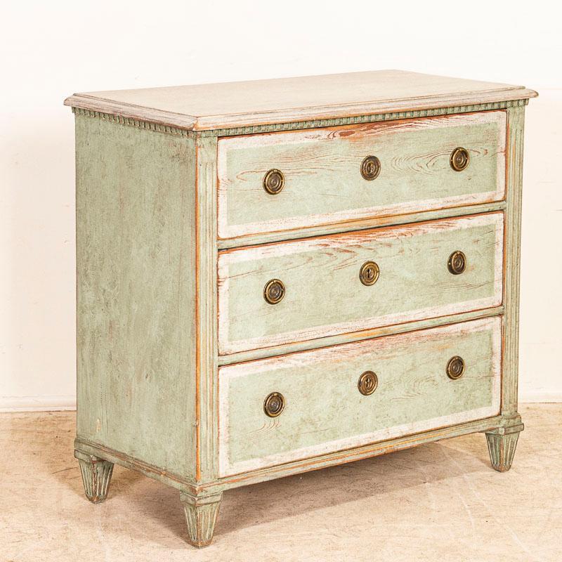 This delightful chest of drawers has a seafoam green painted finish trimmed in soft white. The gentle distressing throughout adds an aged grace to the dresser as well. Two brass pulls on each drawer makes it easy to access the three drawers. This