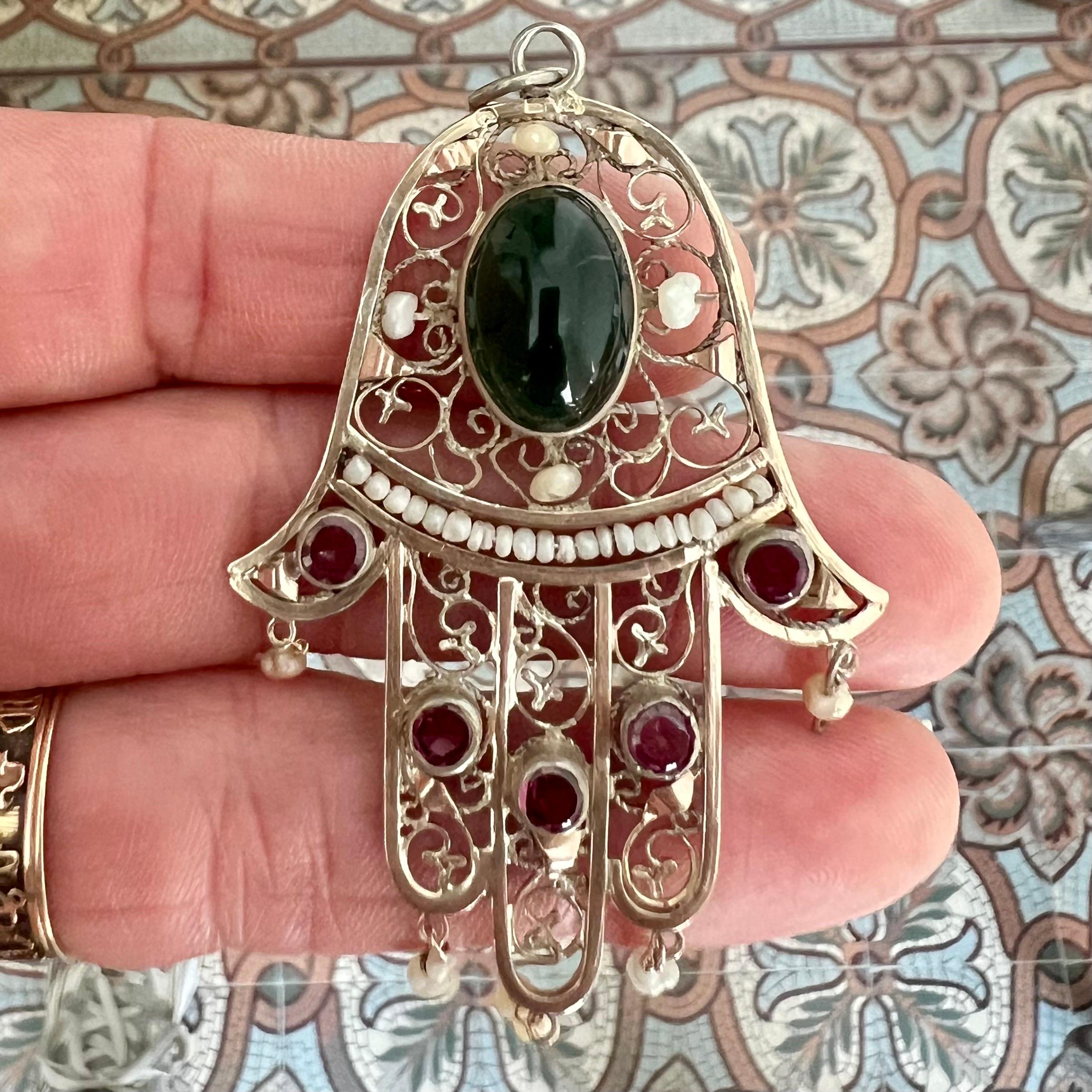 Questo ciondolo antico di seconda scelta in argento con la mano di Fatima Hamsa è un gioiello di grande impatto visivo e ricco di simboli. A forma di mano Hamsa, questo antico simbolo è ampiamente riconosciuto in tutte le culture, in particolare in