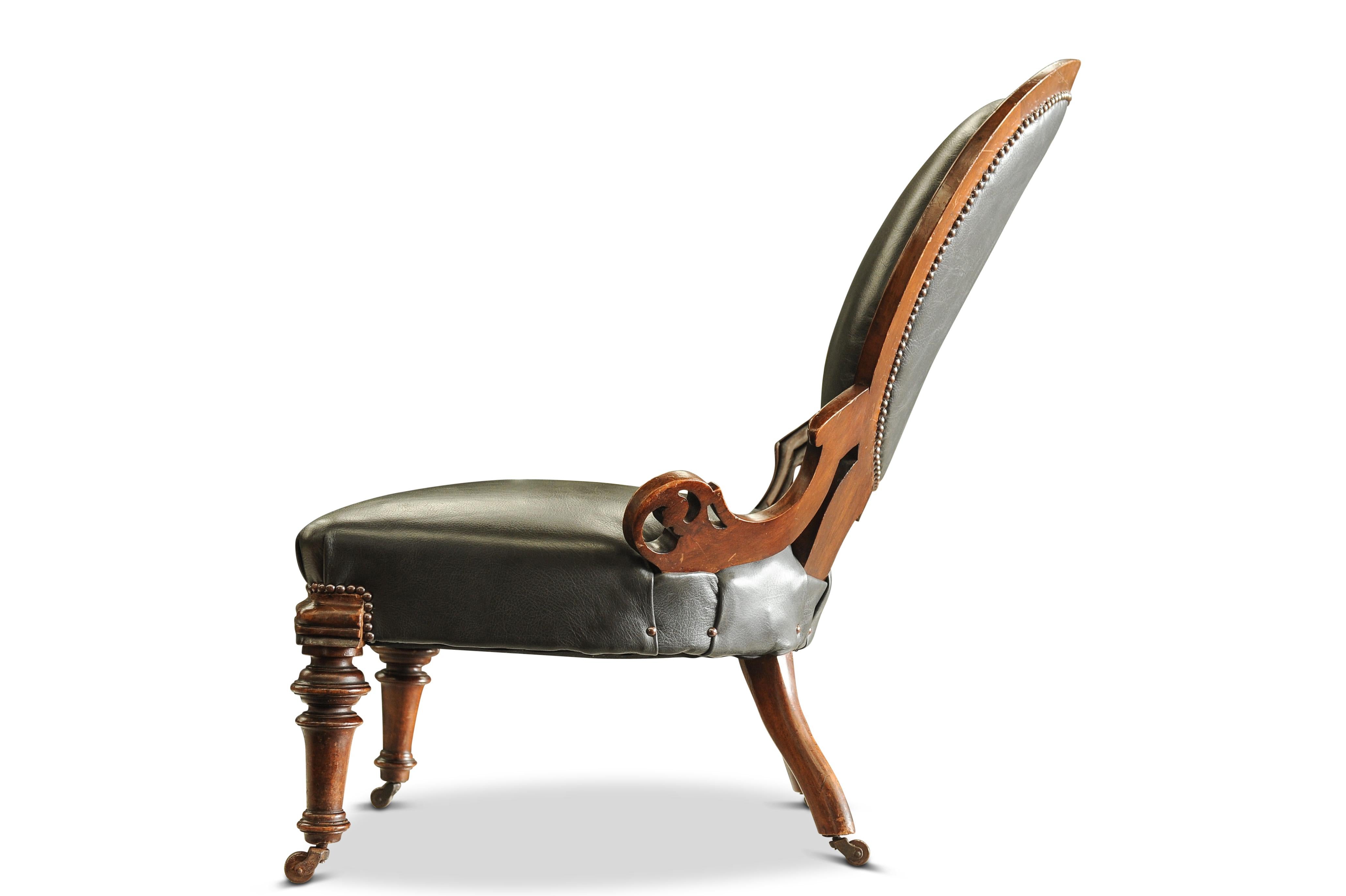 Magnifique fauteuil anglais ancien en cuir et noyer avec motifs sculptés, clous en laiton et roulettes en céramique d'origine Regency Circa 1830's


