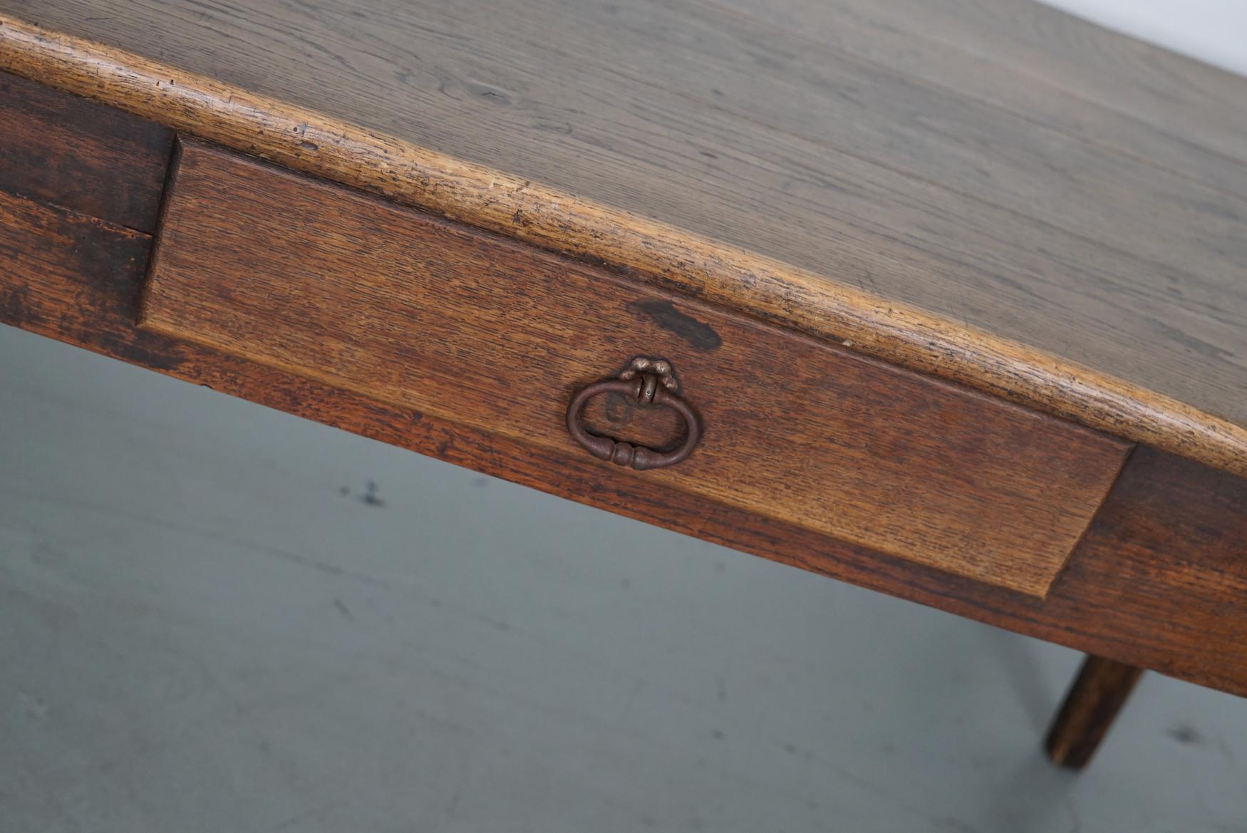 Cette élégante table a été fabriquée en France au XIXe siècle. La table a été fabriquée en chêne massif avec de magnifiques veinures. La couleur est très chaude et la table présente des marques d'utilisation, des réparations anciennes et une belle