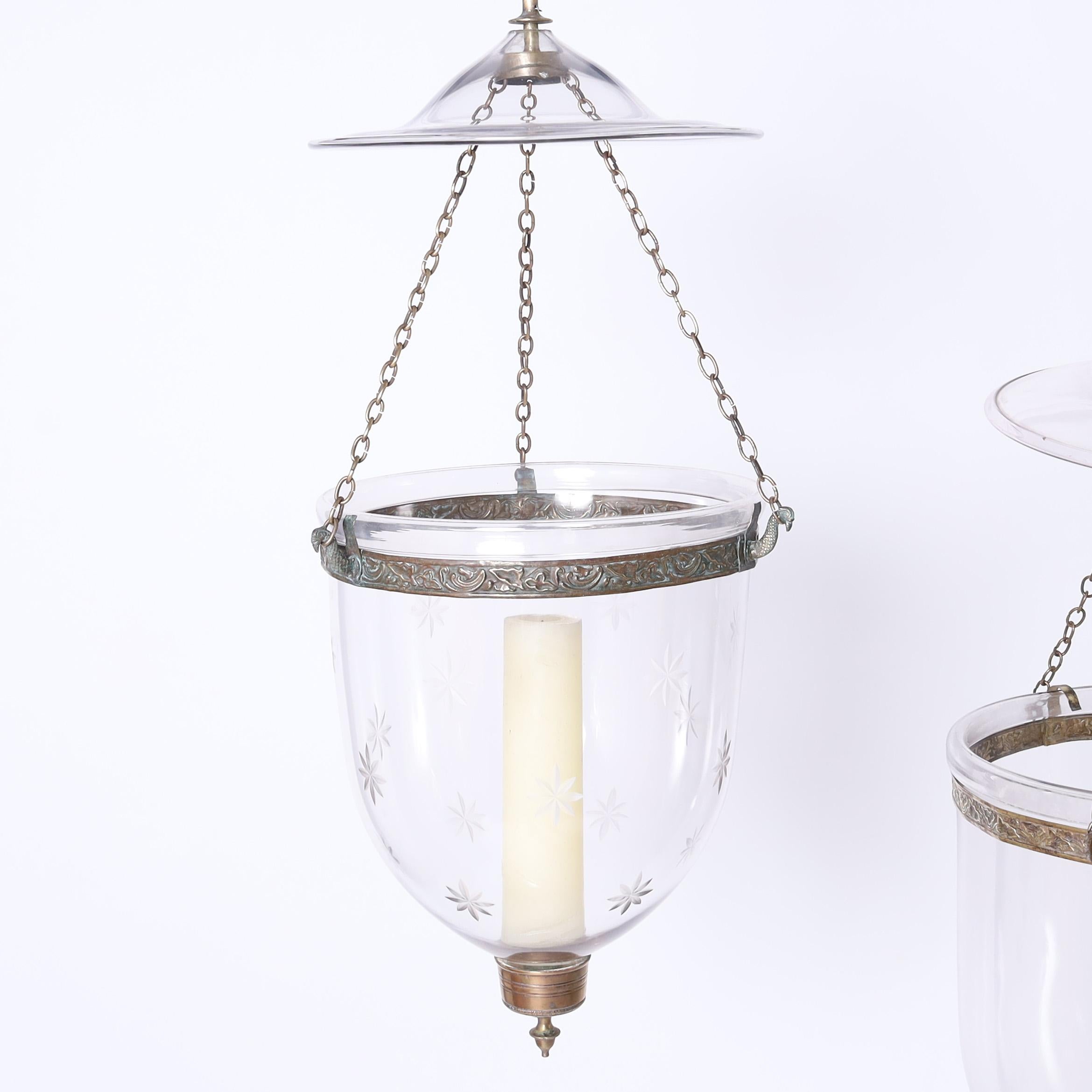 Groupe remarquable de trois luminaires en verre fumé continental de style colonial, soufflé à la main dans une forme classique avec des motifs taillés et des ferrures en laiton martelé, utilisant la puissance des bougies comme conçu à l'origine. Non