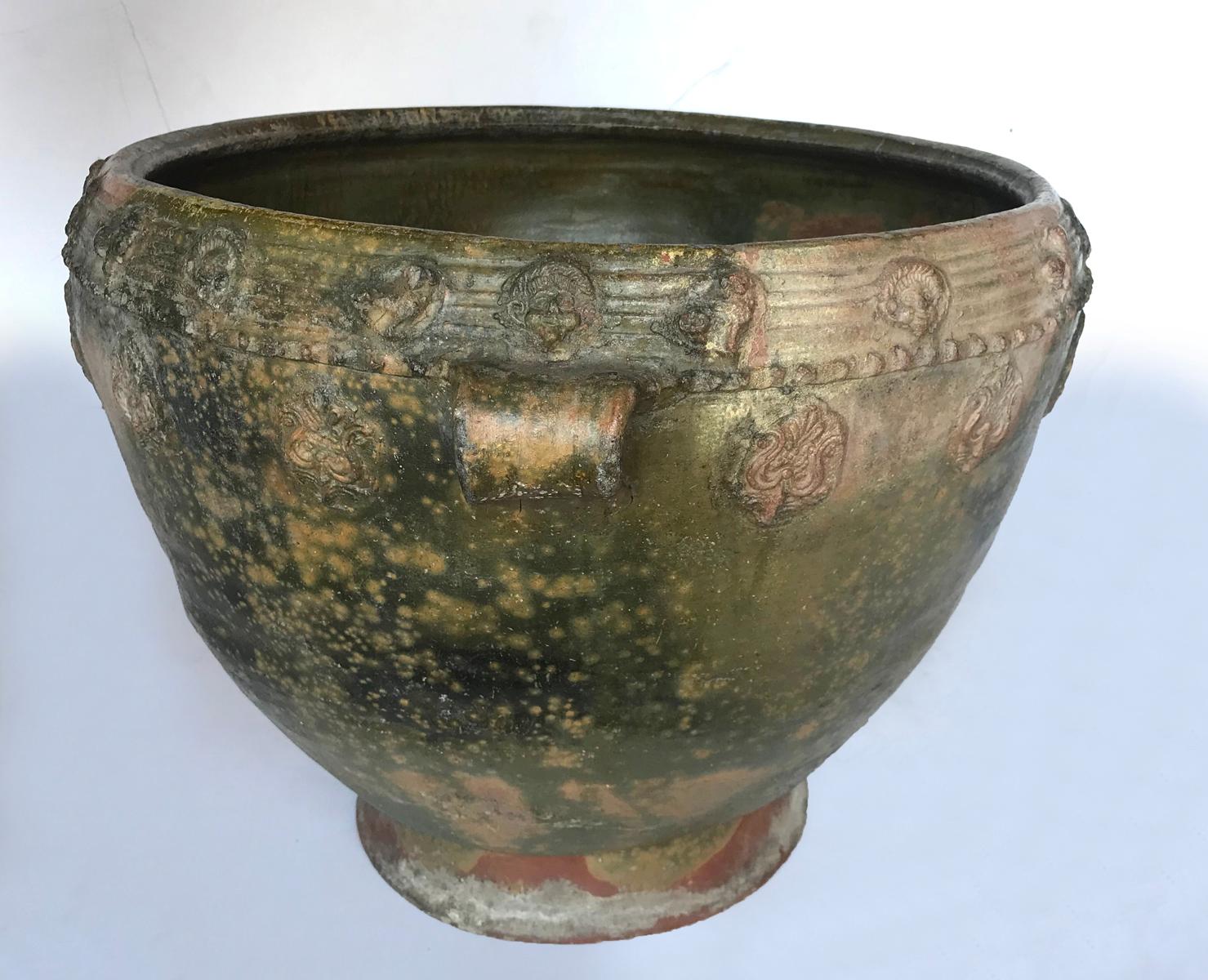Early 20th century water pot, a Trubal,  from the highlands of Central America.   Delicate applied pottery decorations of animals and faces surround the outer edge. Handmade, wood fired, resulting in a lovely greenish, earthy glaze.
Sturdy and