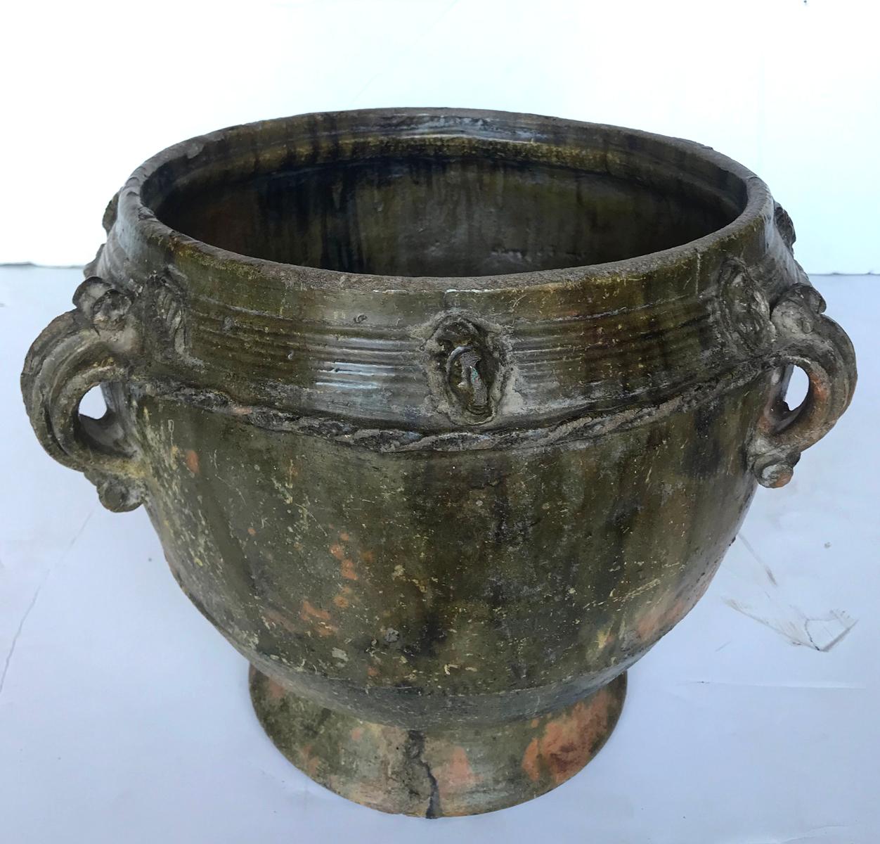 Early 20th century earthenware water storage pot, from the highlands of Central America. Raised and applied decorations throughout depicting faces and botanicals. Green glaze. Handmade, wood fired, resulting in a lovely greenish, earthy