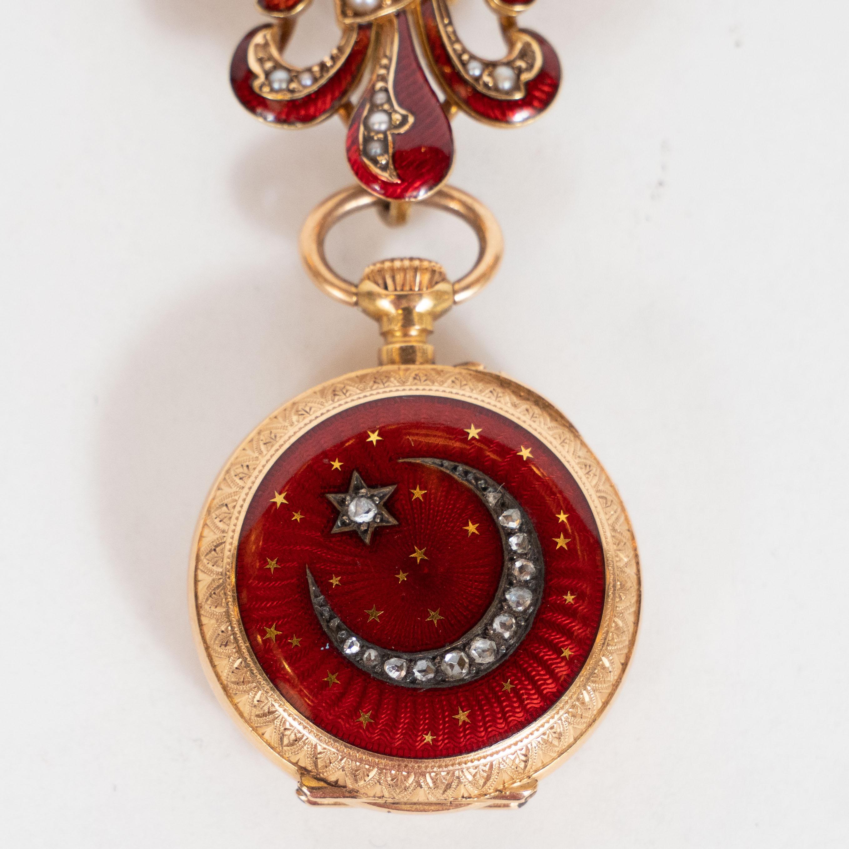 This elegant antique lapel was realized in France, circa 1860. It features a circular pendant composed of 18kt yellow gold with crescent moon and star inlaid in starburst guilloche ruby enamel with rose cut diamonds. The watch pendant, inscribed on
