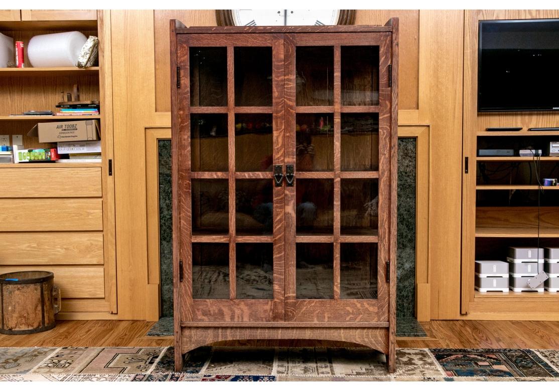 An antique Gustav Stickley China Cabinet circa 1910, made in Eastwood, NY and signed on the label.

The cabinet features quarter sawn white oak construction with raised ears and tenon joinery along the top forming a partial gallery over double doors