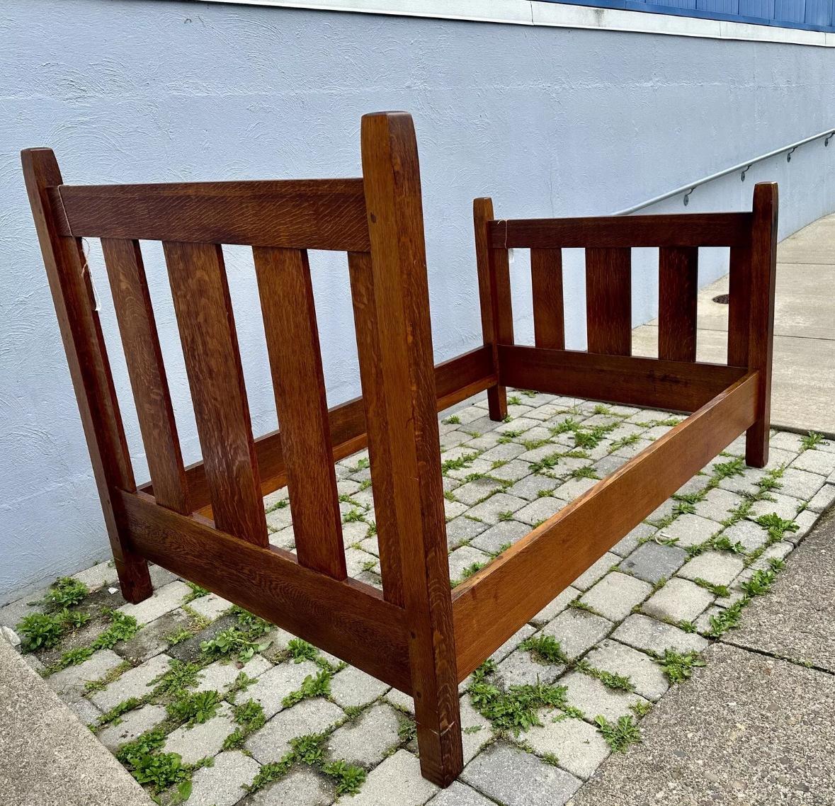 This is an antique three-quarter bed from early 1900s in good condition. Made from quarter sawn oak, the bed is marked with Gustav Stickley paper label as pictured with original finish. STURDY & STRONG, this bed is ready for use in your home and its
