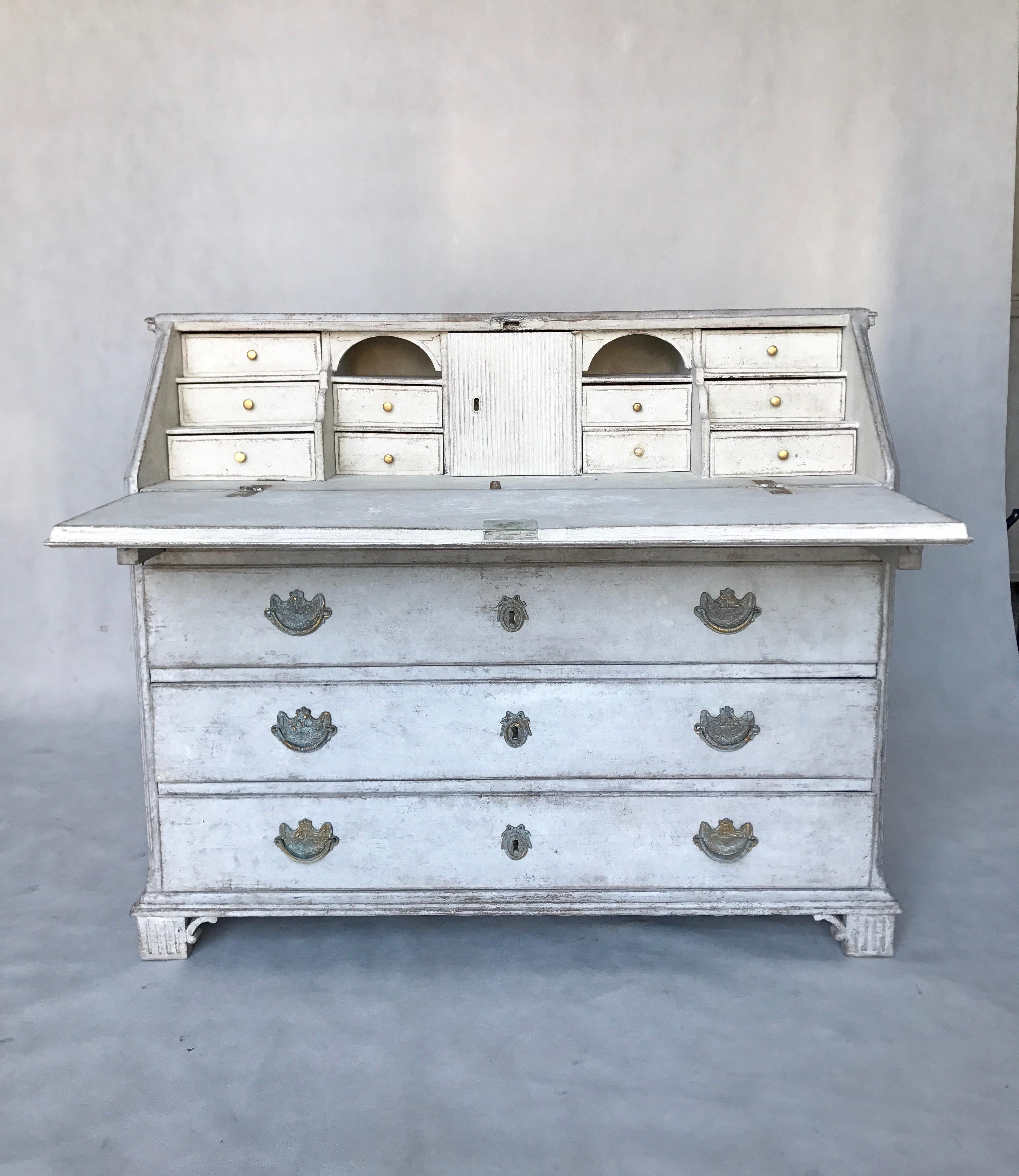 This is an 18th century Gustavian period bureau with a fall front desk featuring a multitude of compartments. It has a slim letter drawer with dentil frieze, three further drawers, decorative shaped bracket feet, original hardware, and locks. This