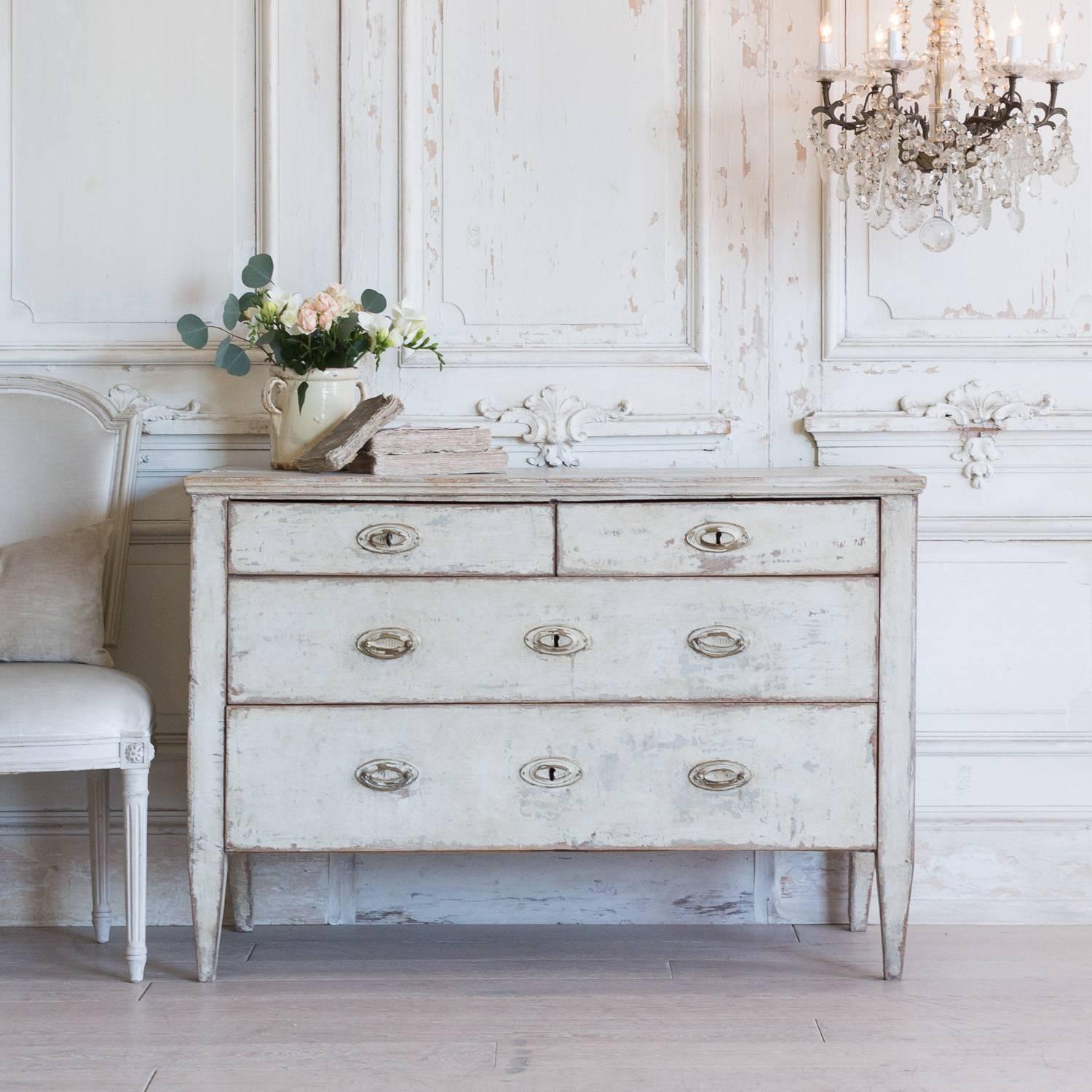 Gorgeous antique dresser with four drawers. The distressed hardware complete with a with functional key adds to the presentation of this piece. The age shows beautifully through the layers of paint and chipping presented throughout this piece. A
