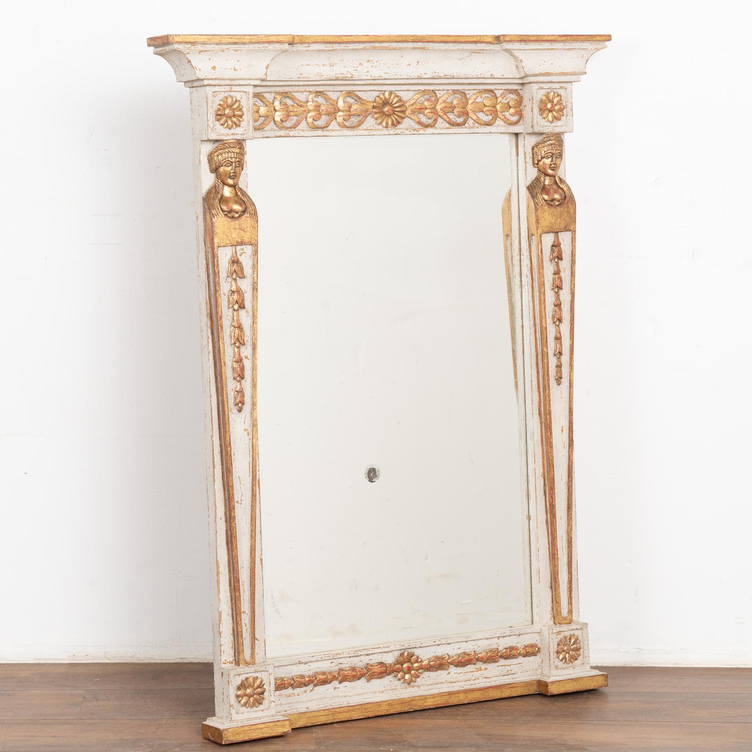 Joli miroir de style gustavien avec une finition peinte en gris clair avec des nuances de blanc. Accents sculptés en or doré avec des nuances de rouge.
D'une hauteur d'un peu moins de 4 pieds, sa taille lui permet d'être exposée dans une grande