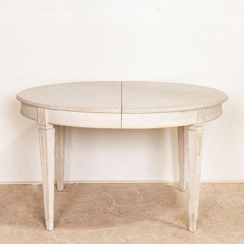 The graceful lines of the gustavian period are seen in the tapered legs of this lovely Swedish dining table. It is the (more recent) white painted finish that captures the eye and adds a touch of romance to it as well. There is one removable leaf at
