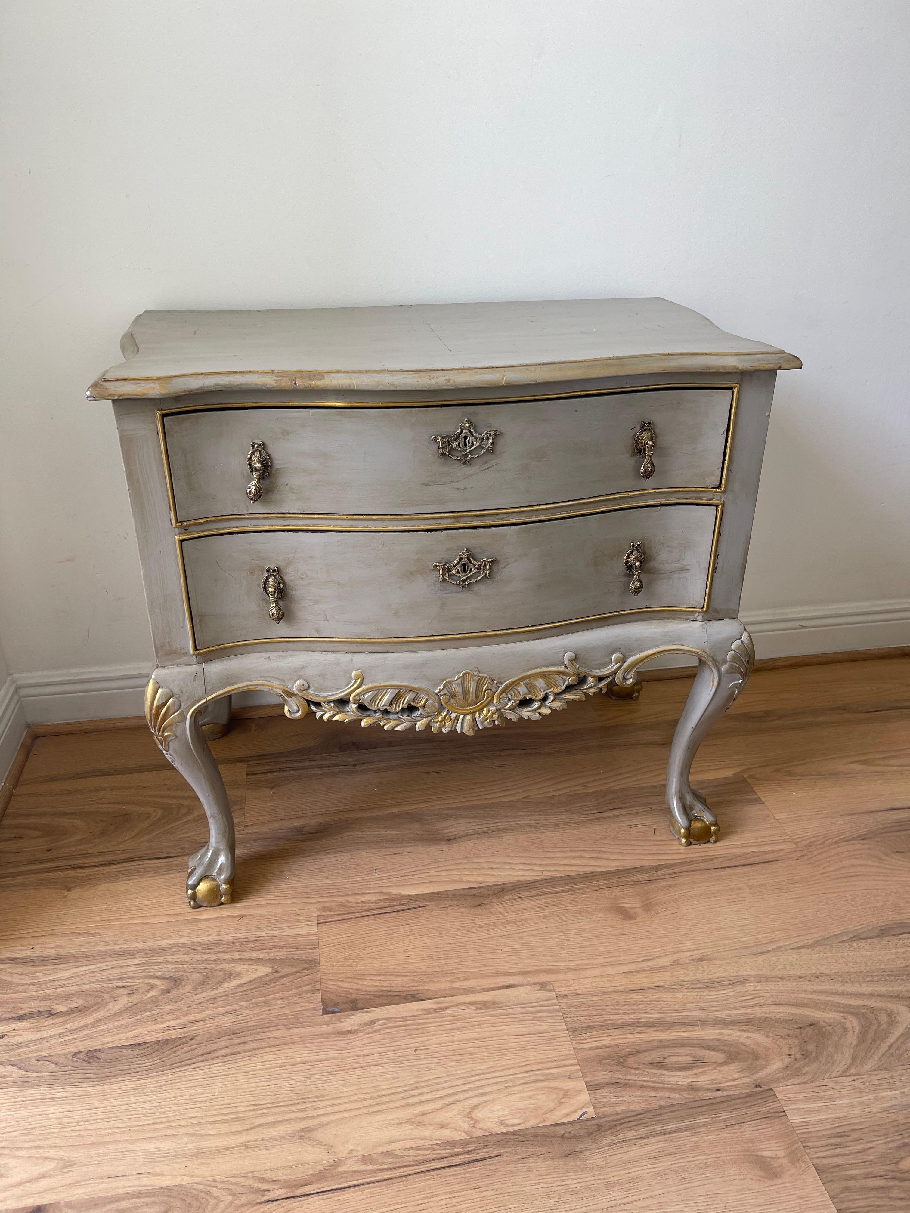 Bellissima commode del 19° secolo a due cassetti impiallacciati in noce su gambe cabriole con piedi a sfera. Fronte a serpentina, grembiule intagliato a mano. Dipinto di grigio e finiture dorate in stile gustaviano.