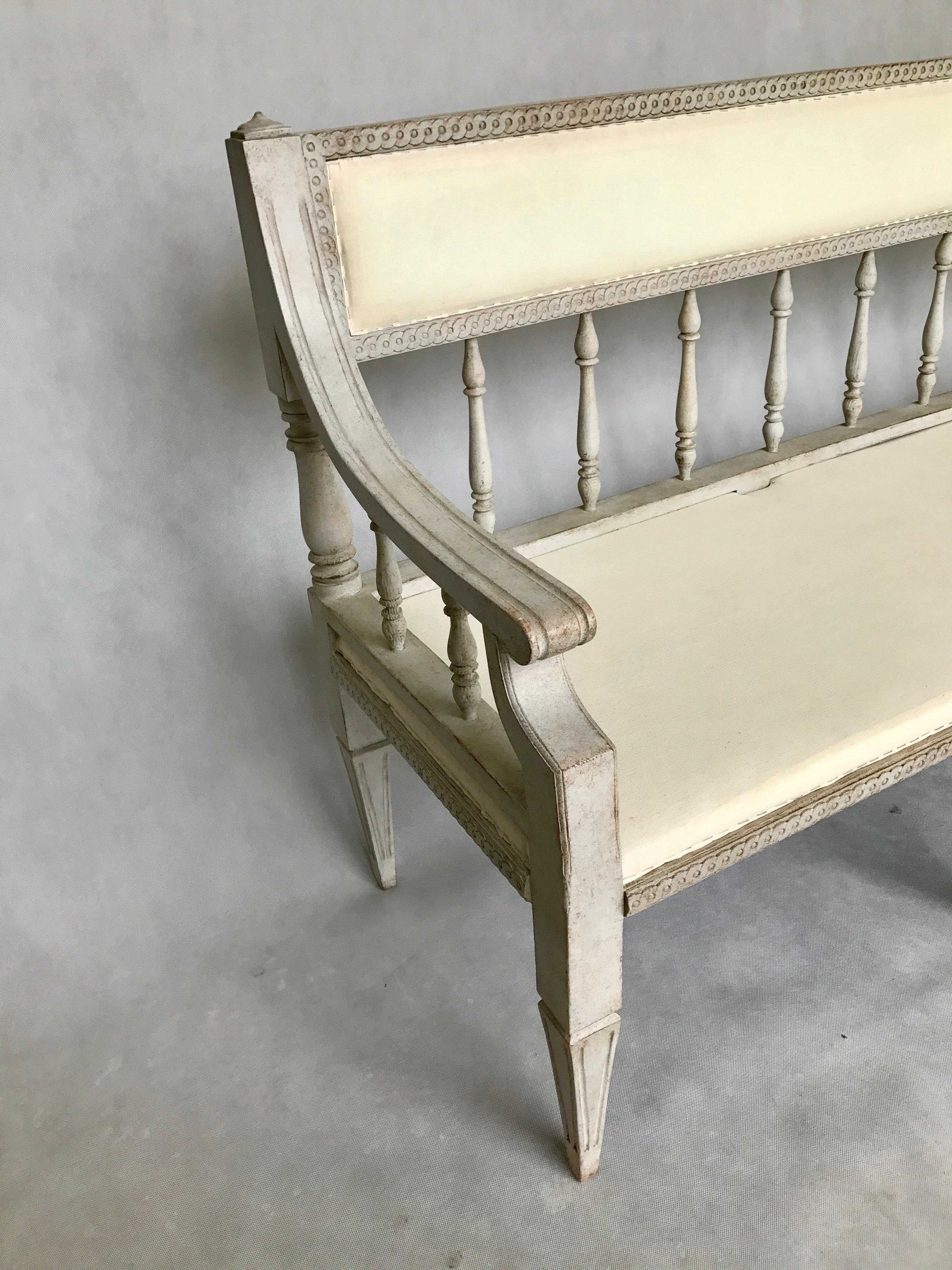 This three-seat in the Gustavian style sofa was recently upholstered in white linen.